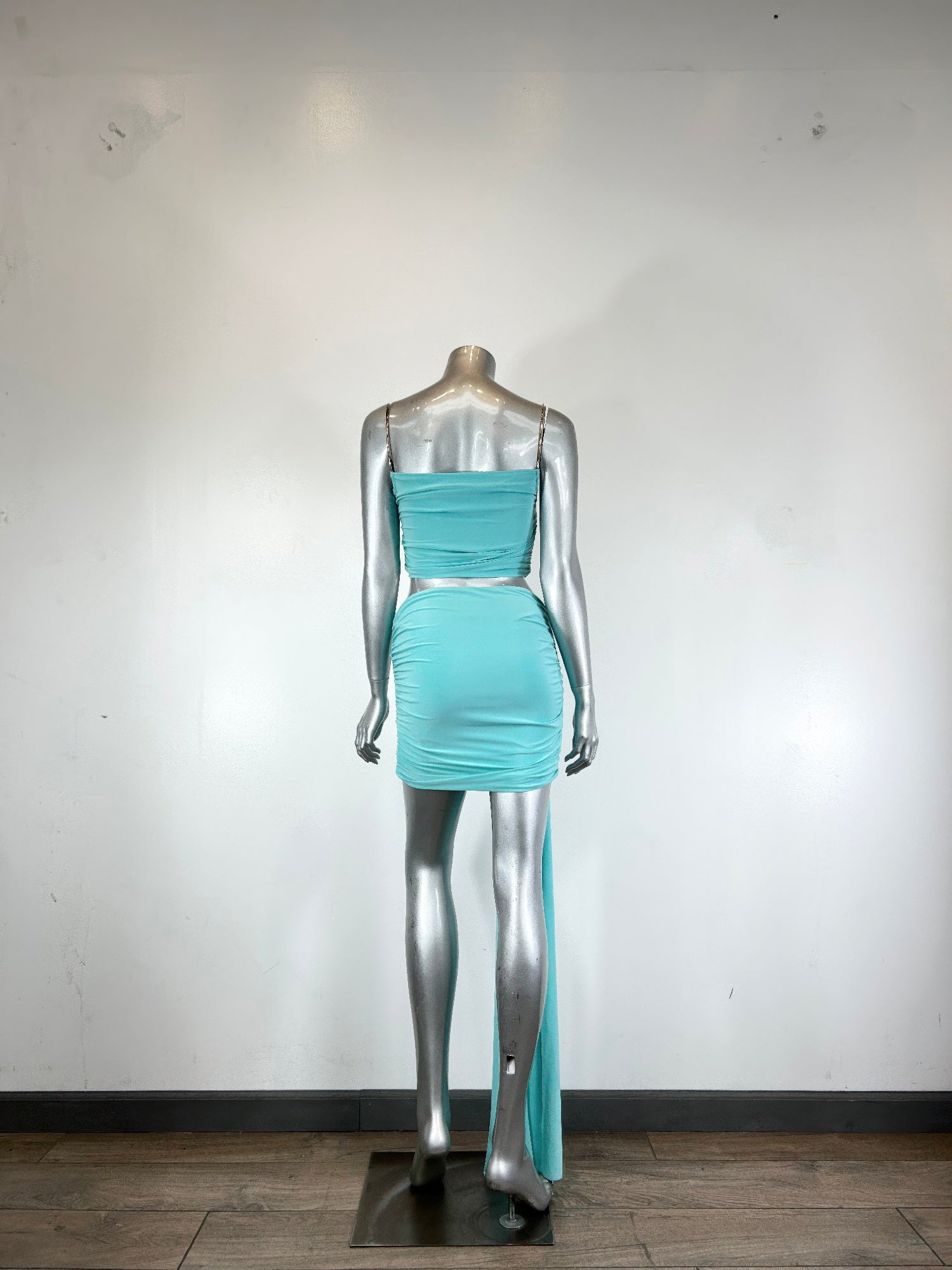 Mannequin view: aqua cropped bodice and ruched mini skirt with long trailing drape
