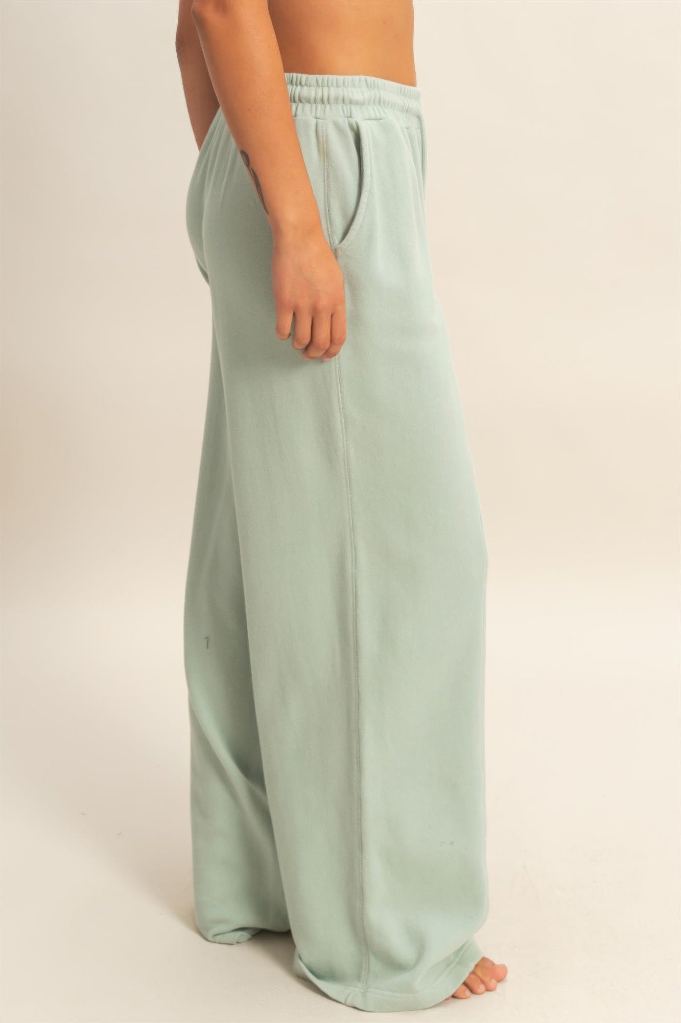 Light mint wide-leg pants with relaxed drape, side seam lines, elastic waist