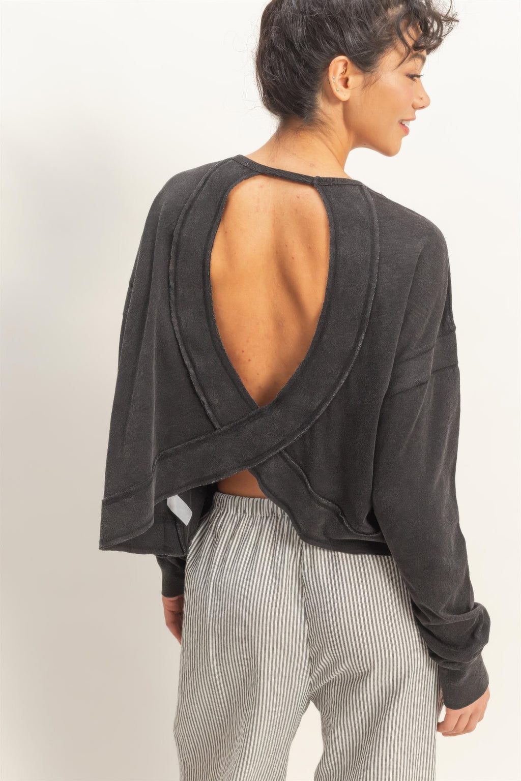 Black open-back long-sleeve top with crisscross cross-detail panel on back