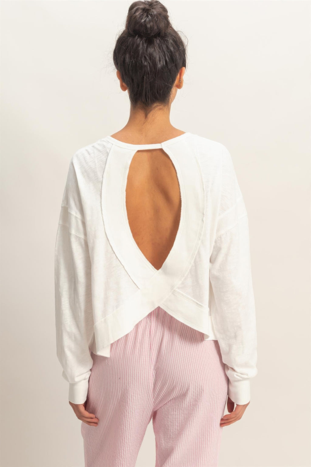 White long-sleeve top back view: deep open back with cross overlay