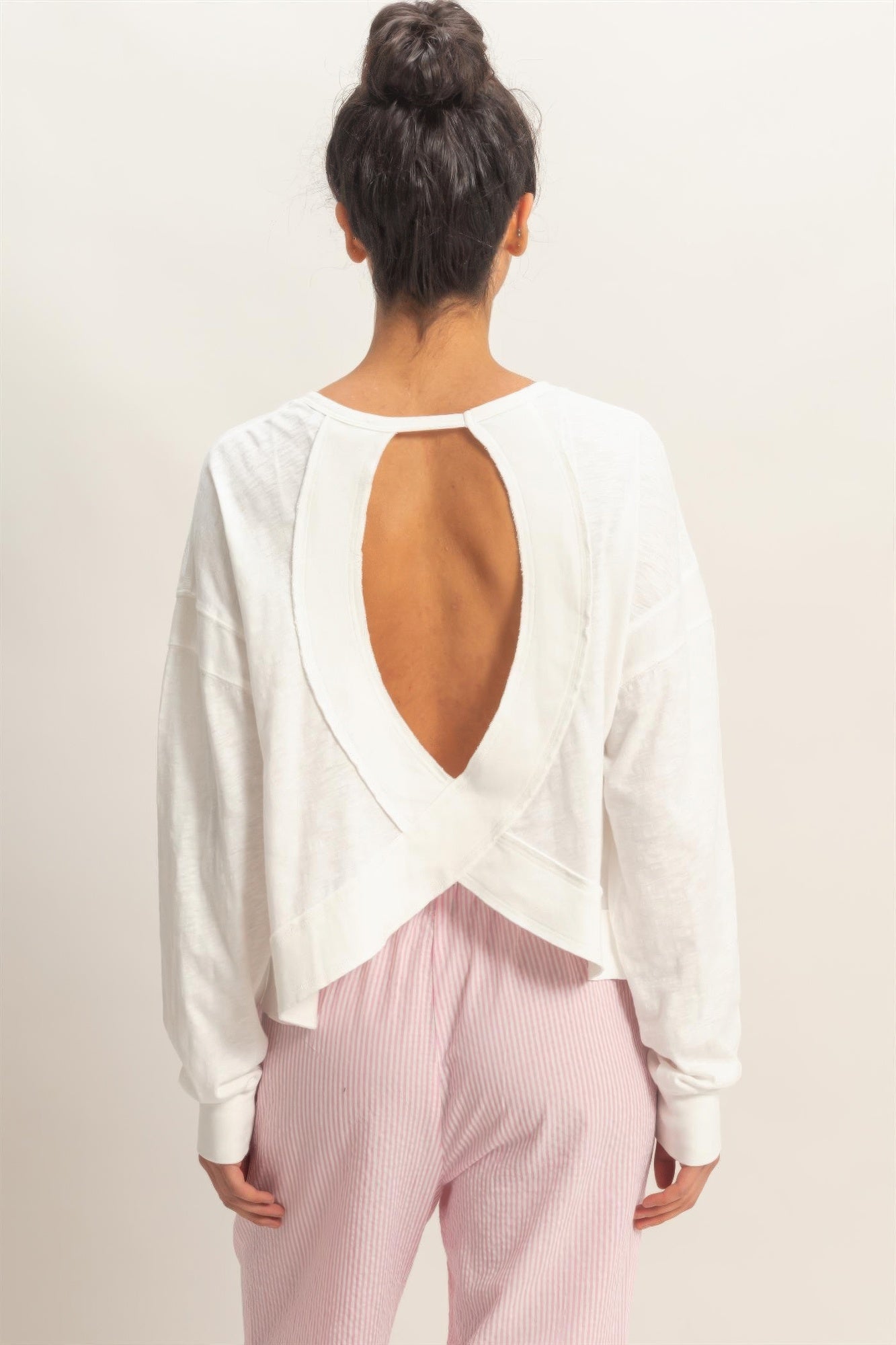 White long-sleeve top back view: deep open back with cross overlay