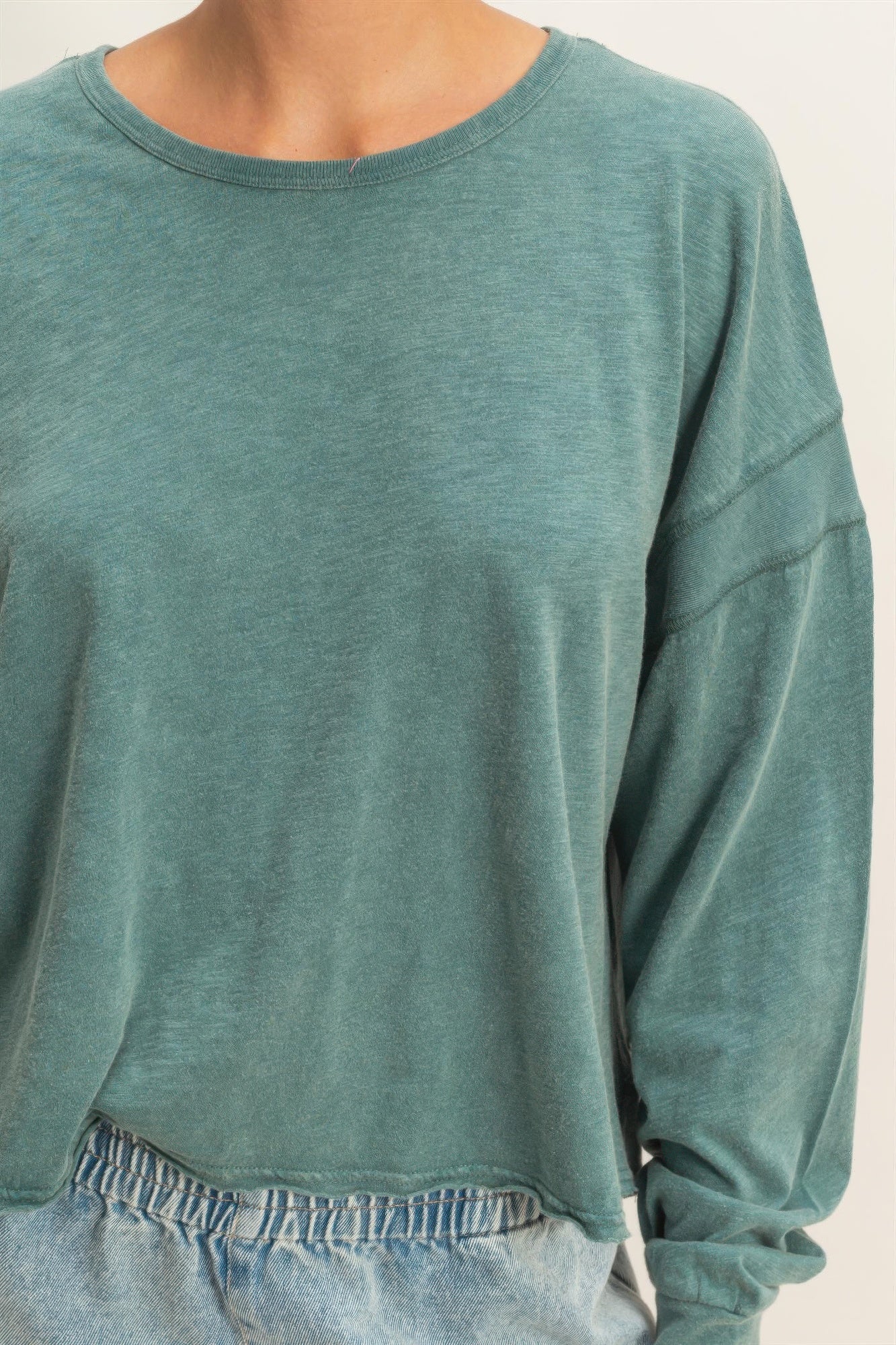 Dark teal long-sleeve top with crew neckline and soft, drapey fabric