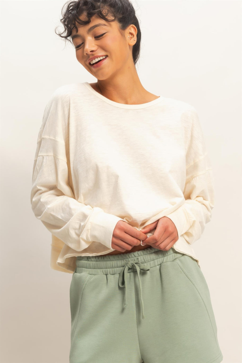 White long-sleeve open-back top with crew neck and relaxed fit; soft, lightweight fabric