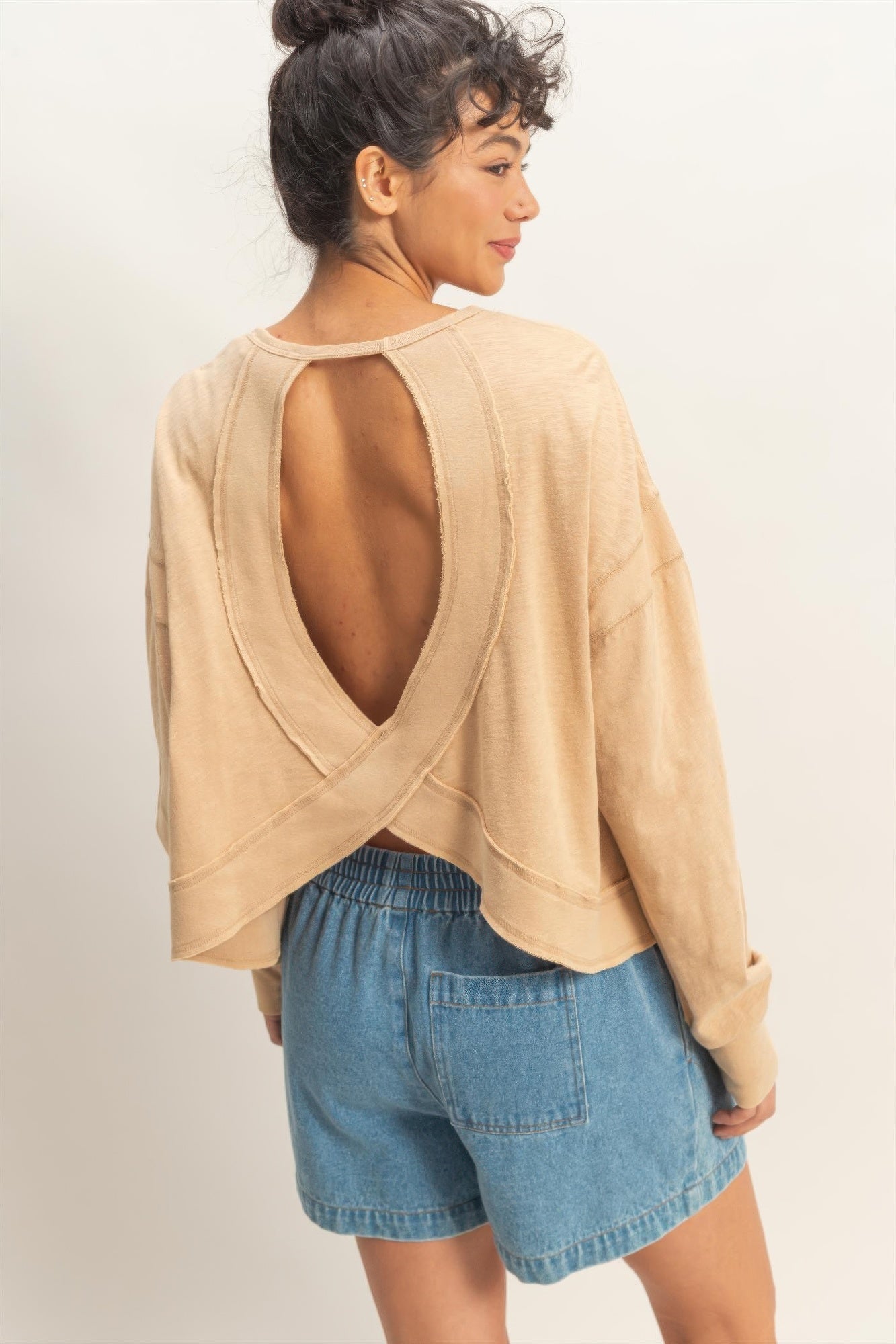 Dark taupe open-back long-sleeve top, crisscross cross detail over the open back