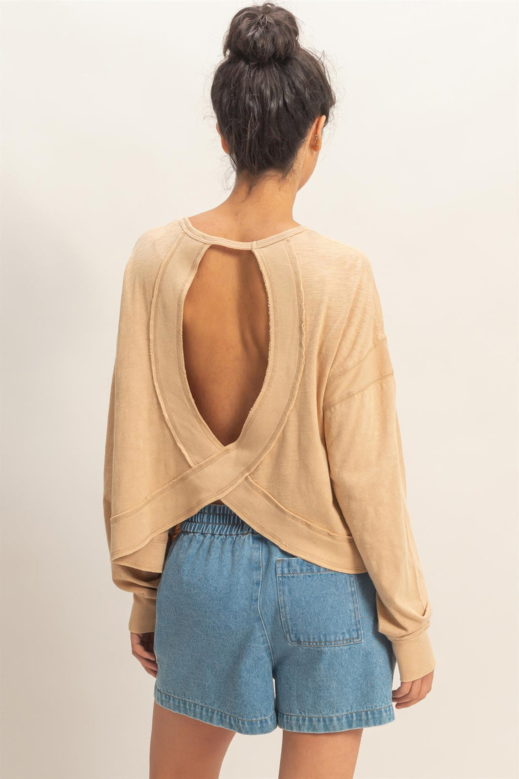 Back view of dark taupe long-sleeve top with deep oval open back and crossed straps