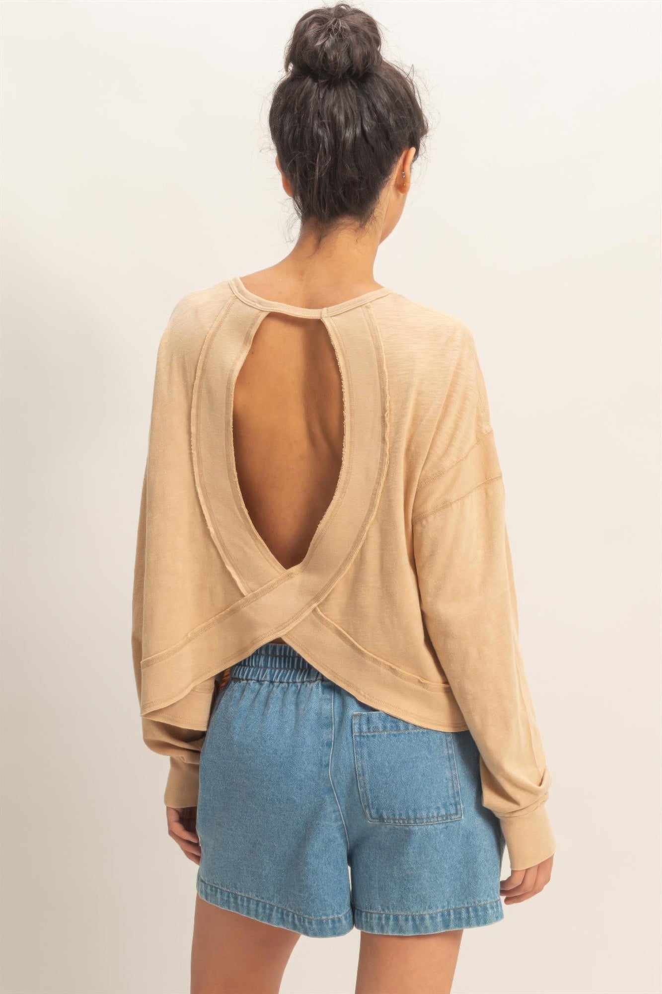 Back view of dark taupe long-sleeve top with deep oval open back and crossed straps