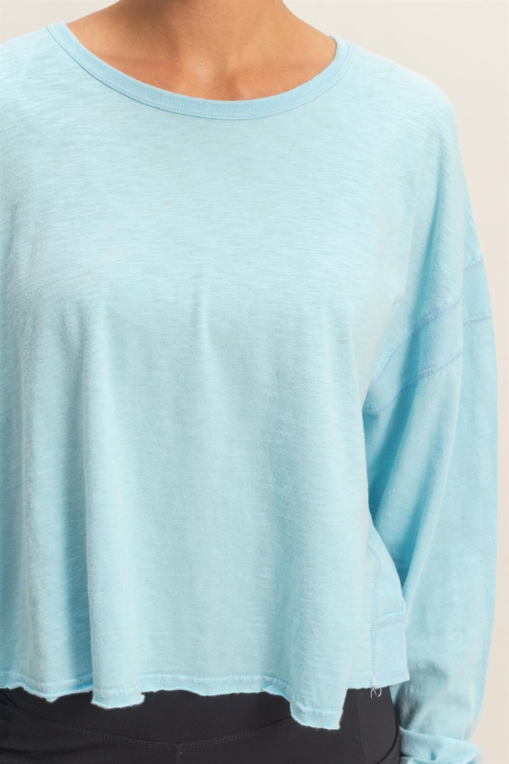 Light blue long-sleeve top with crew neck and relaxed, curved hem