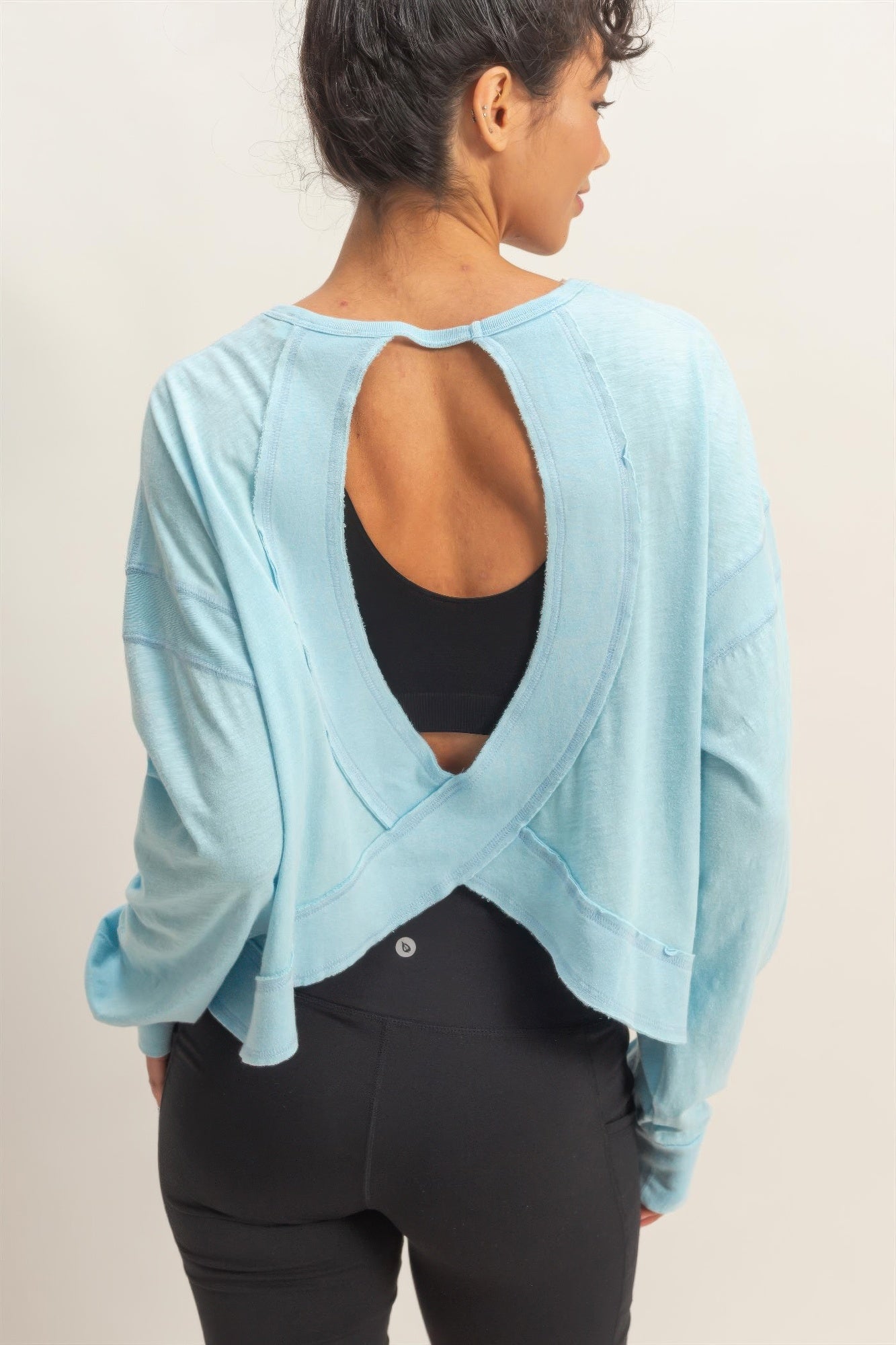 Open-back cross detail, light blue long-sleeve top with deep back cutout
