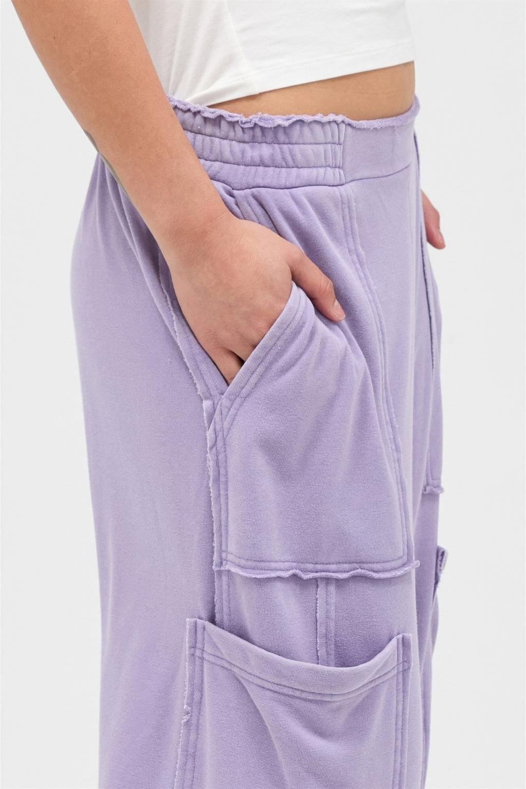 Dusty purple wide-leg cargo pants, elastic waistband and flap pockets close-up