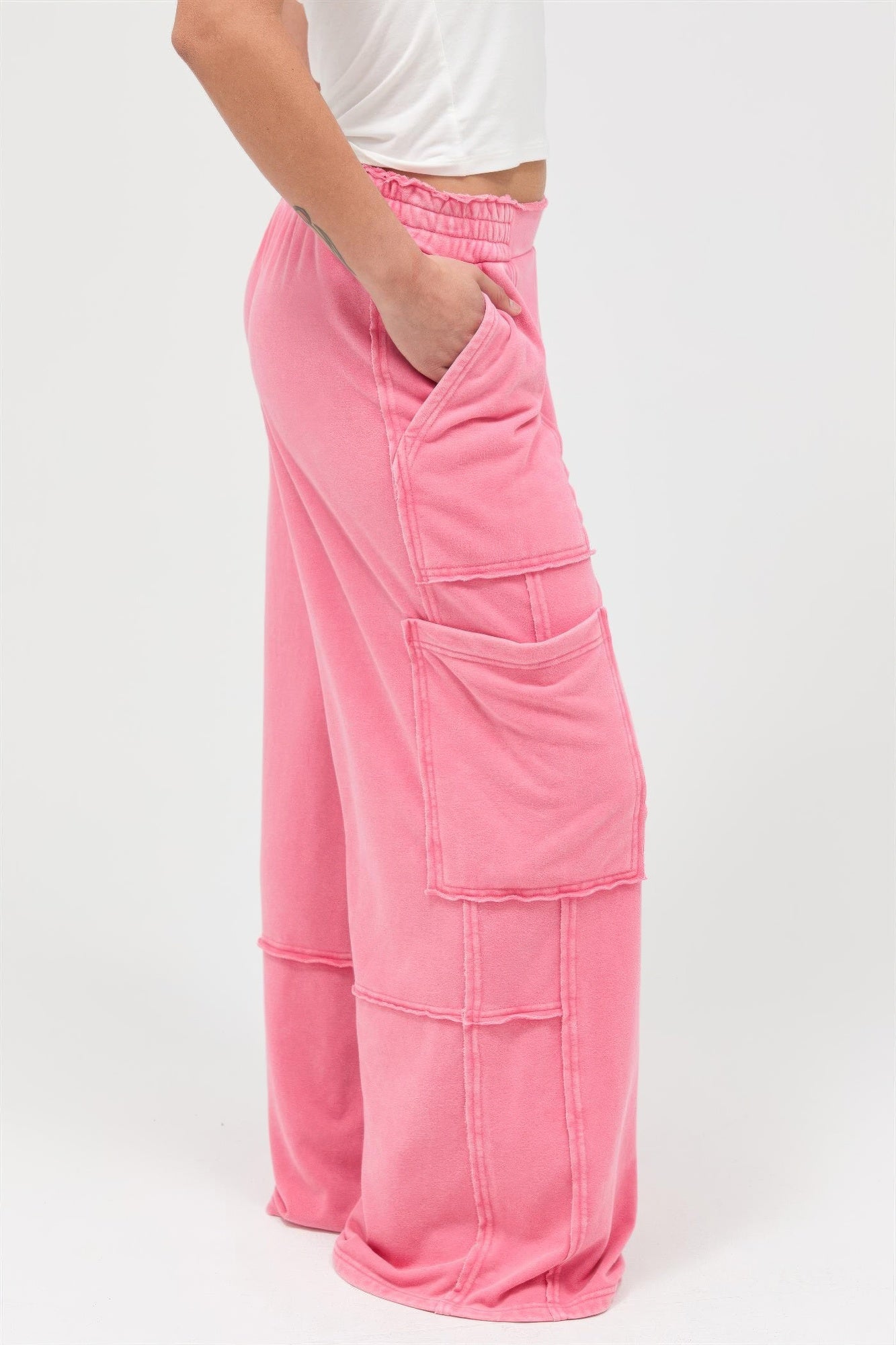 Taffy pink wide-leg cargo pants, side view with stitched panels and flap pocket