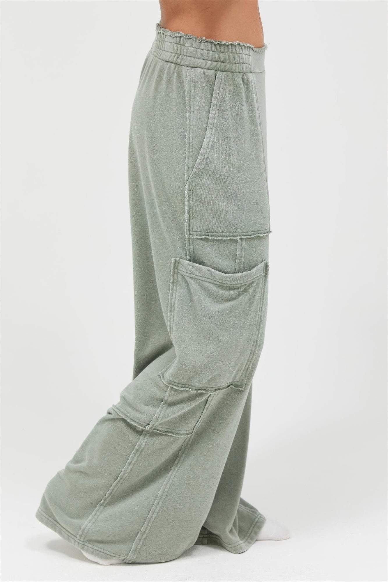 Sage green cargo pants, side flap pocket and seam details on wide relaxed legs