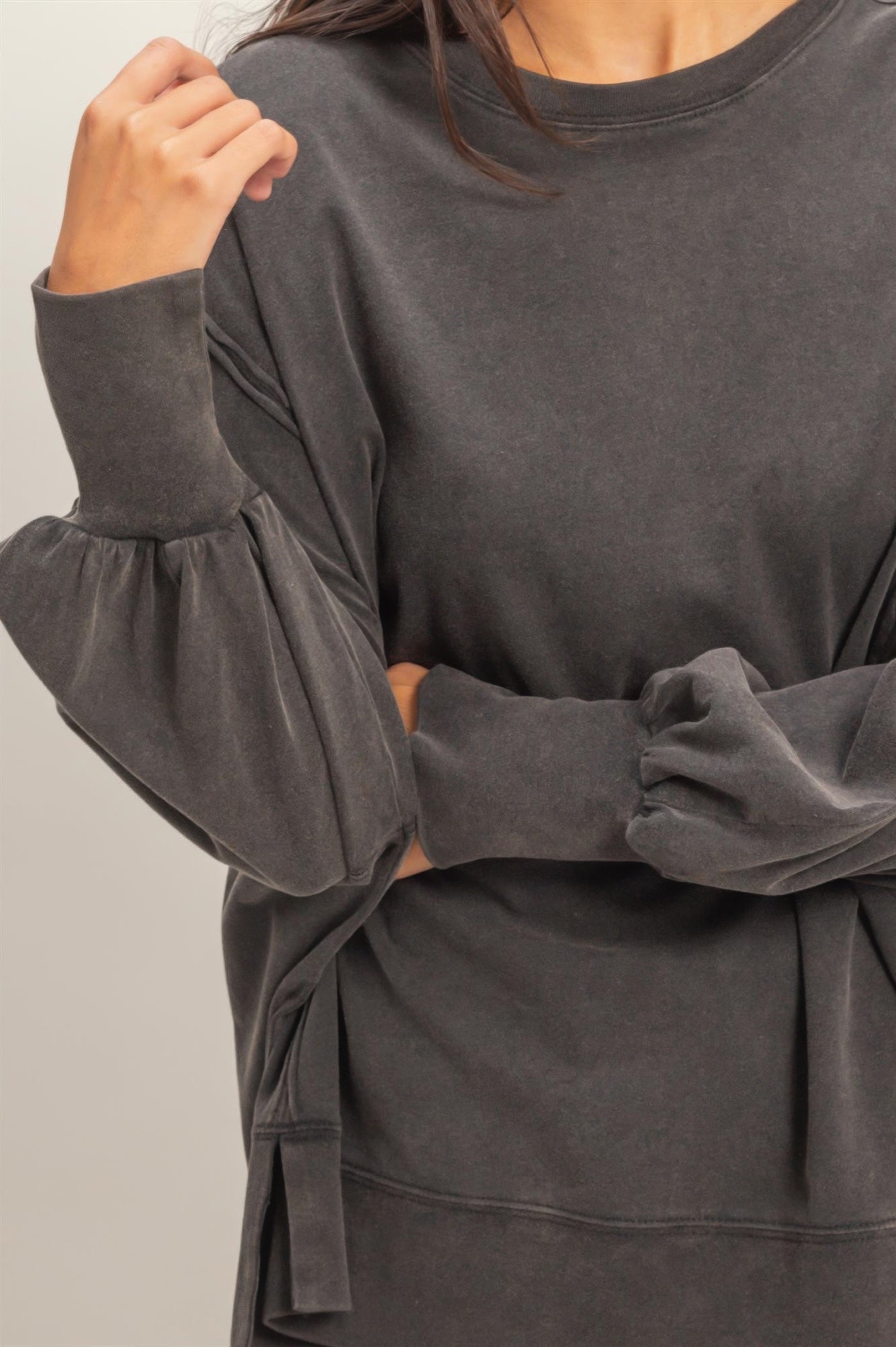 Black oversized long sleeve top, relaxed fit with gathered cuffs and seam detail