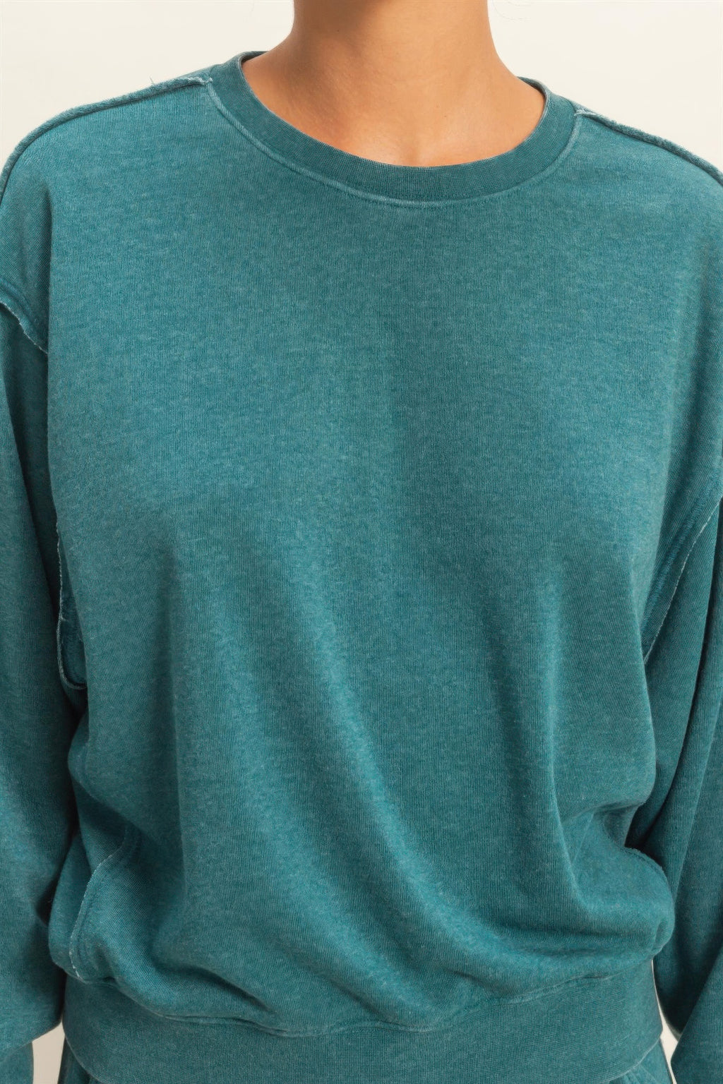 Turquoise crew-neck raw-edge sweatshirt close-up with soft heather knit texture