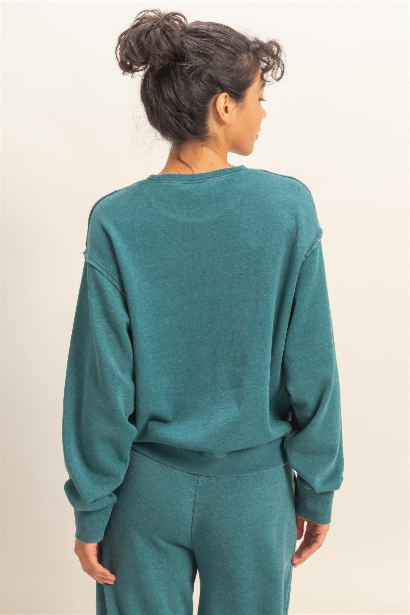 Turquoise raw-edge sweatshirt back view with long sleeves and curved hem