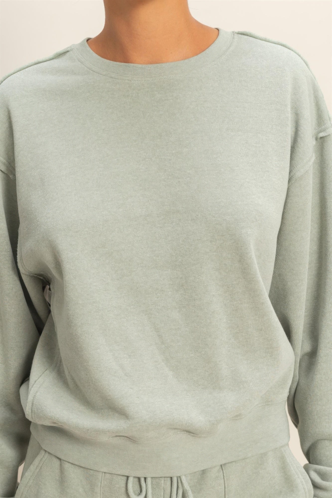Heather grey crew-neck raw-edge sweatshirt close-up showing smooth front panel