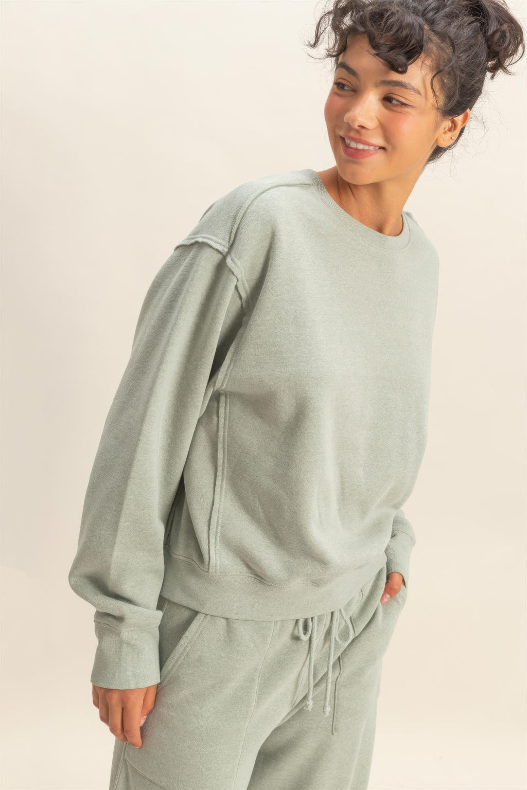 Heather grey raw-edge sweatshirt side view with long sleeves and curved hem
