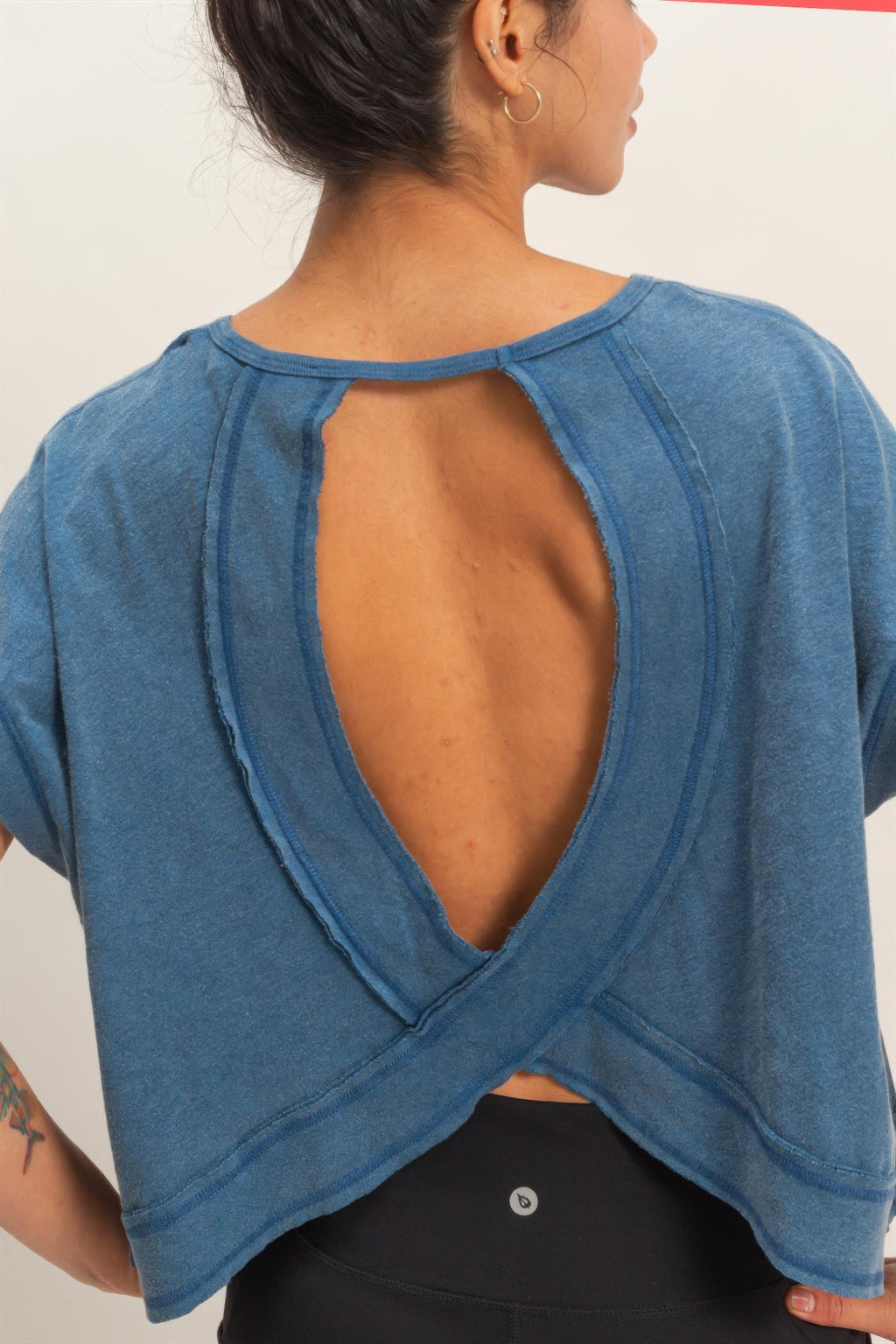 Close-up of blue open back with deep V opening and cross strap seam