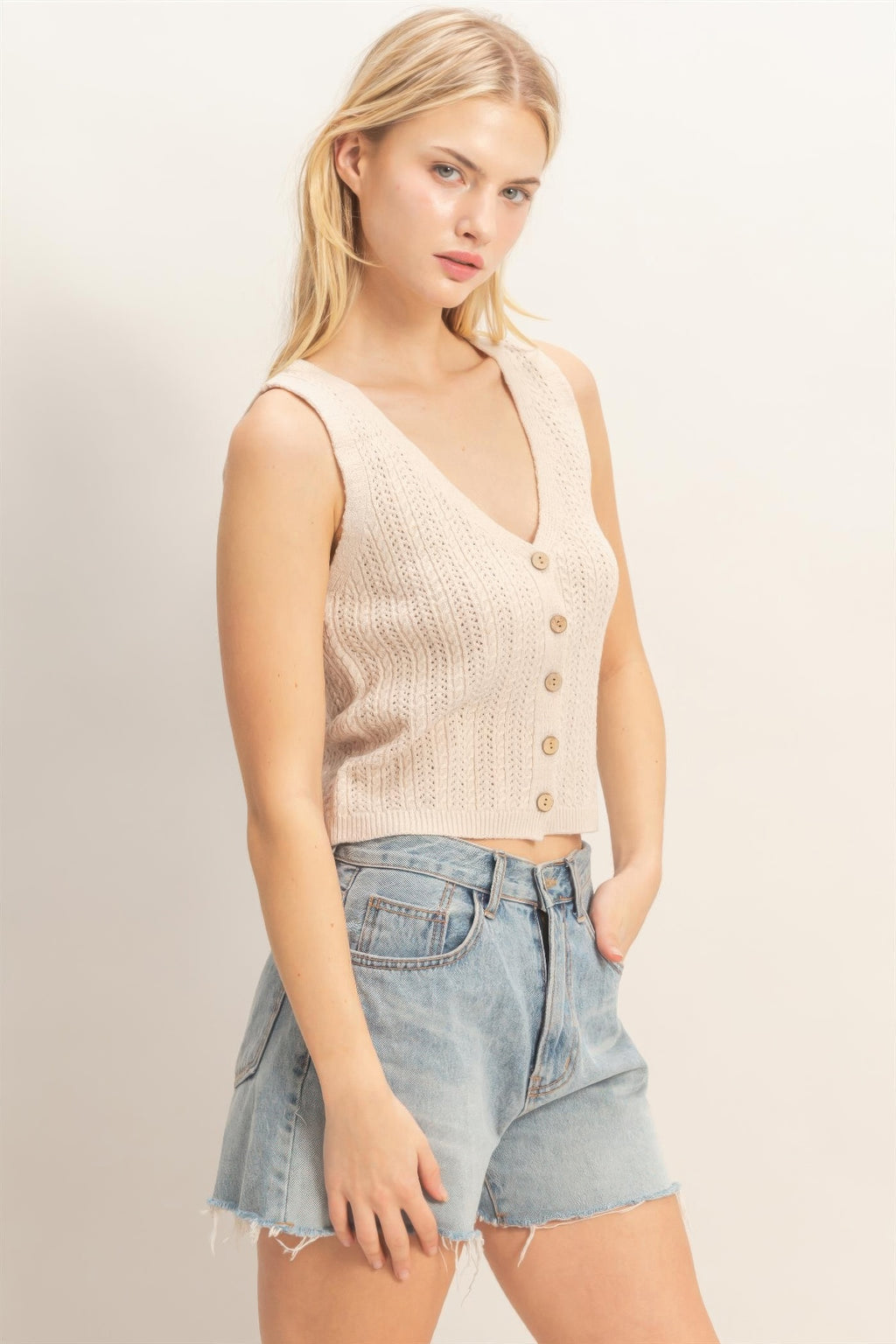 Off-white sleeveless V-neck knit tank top with button placket and ribbed trim
