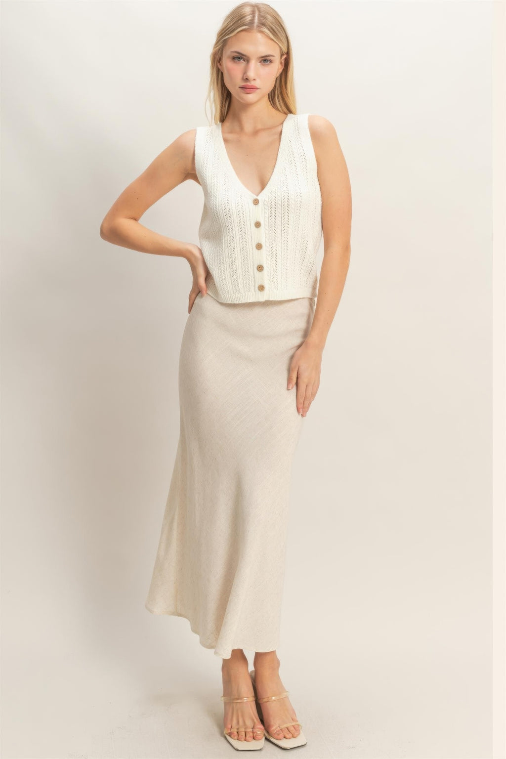 Off-white V-neck knit tank with front buttons and ribbed hem, sleeveless