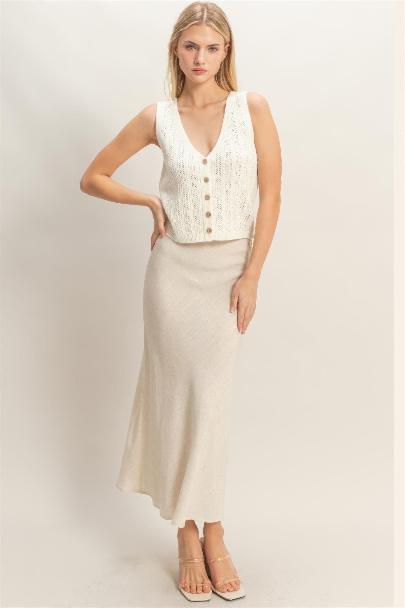 Off-white V-neck knit tank with front buttons and ribbed hem, sleeveless