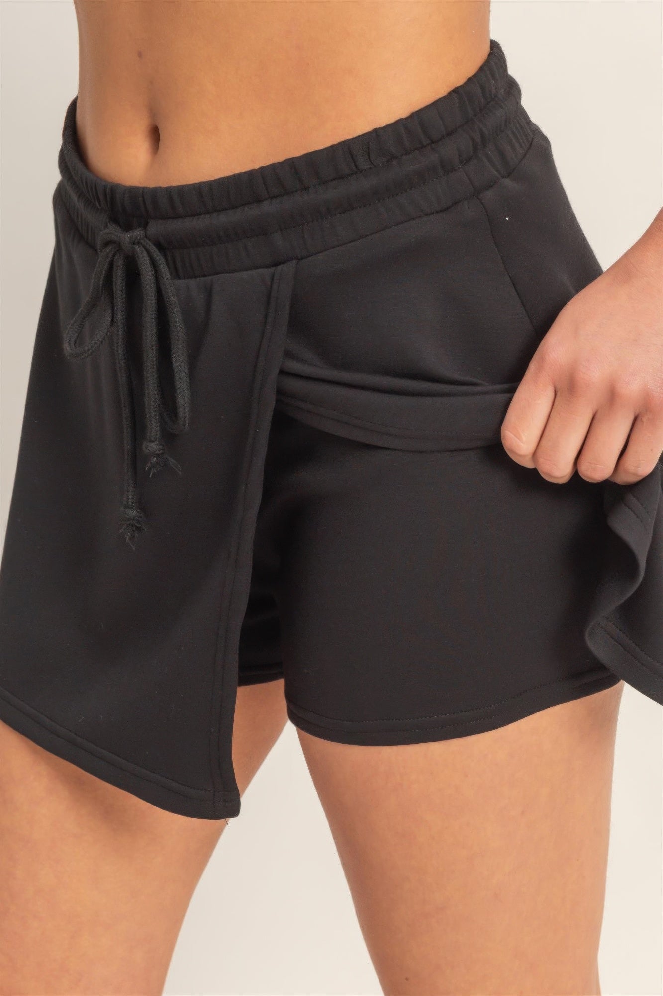 Black skort close-up: elastic waist, tie drawstring, layered wrap look