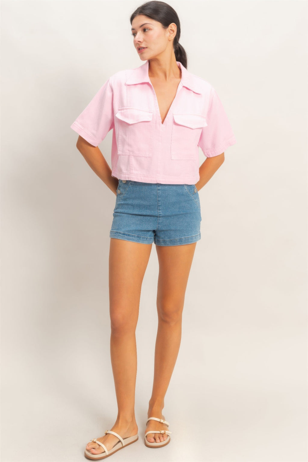 Pink collared V-neck top, side view with button placket and pockets