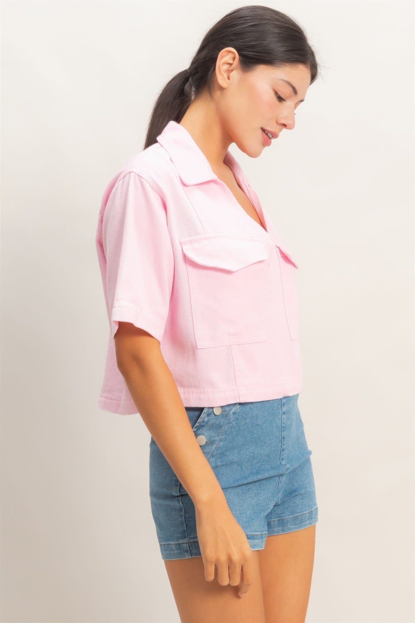 Pink collared V-neck top, angled side view with chest pocket