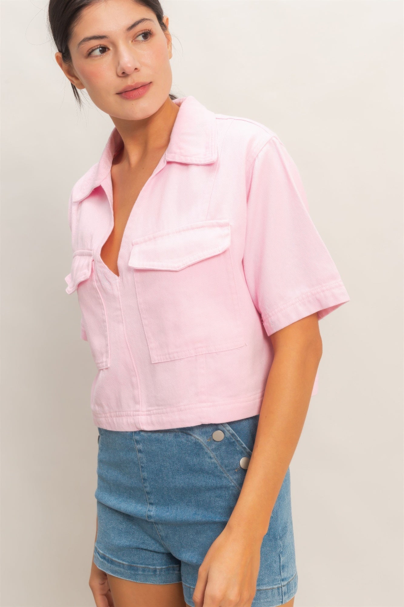 Pink collared V-neck top close-up, chest pockets and short sleeves