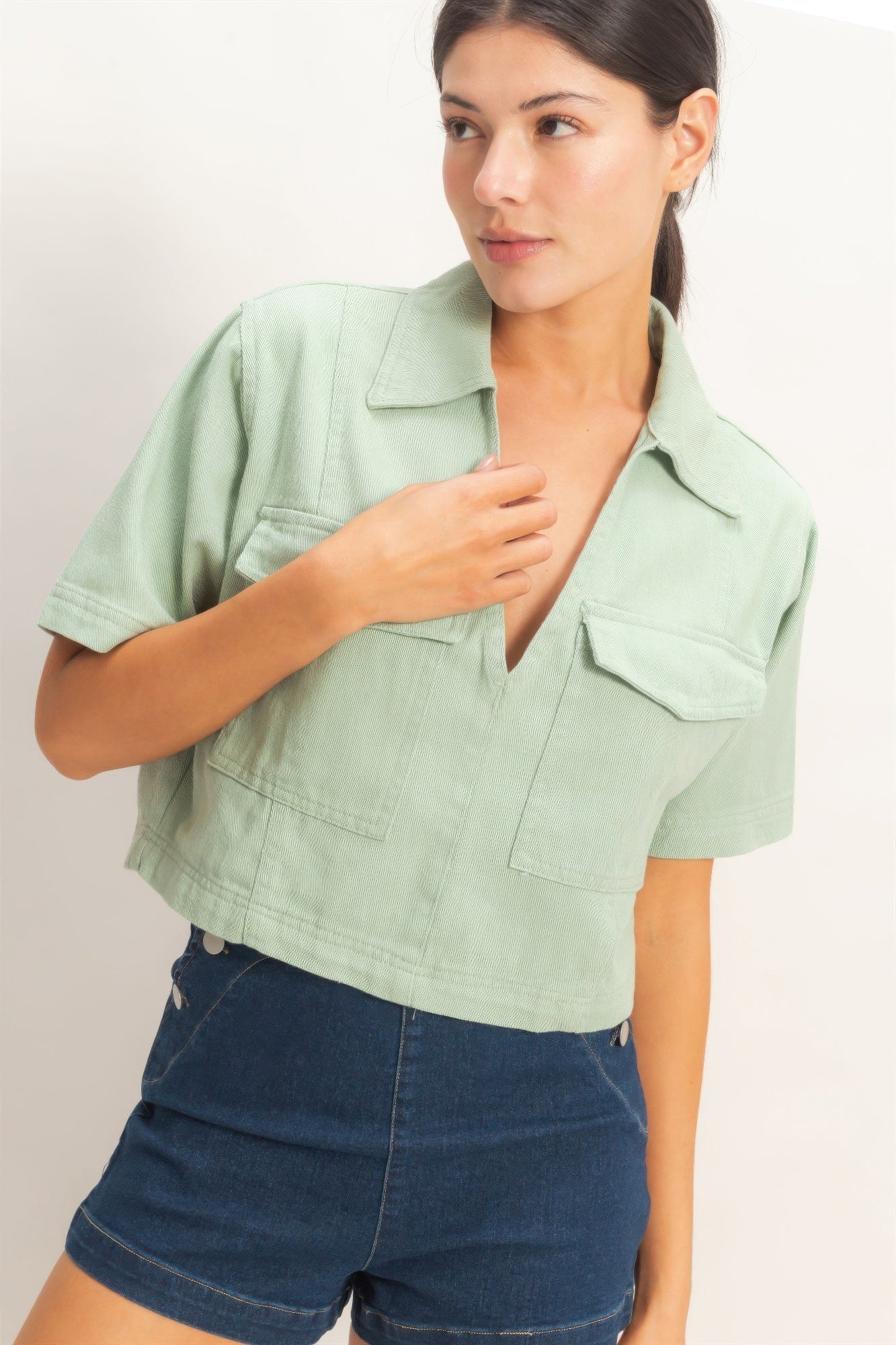 Sage green collared V-neck top with short sleeves and chest flap pockets