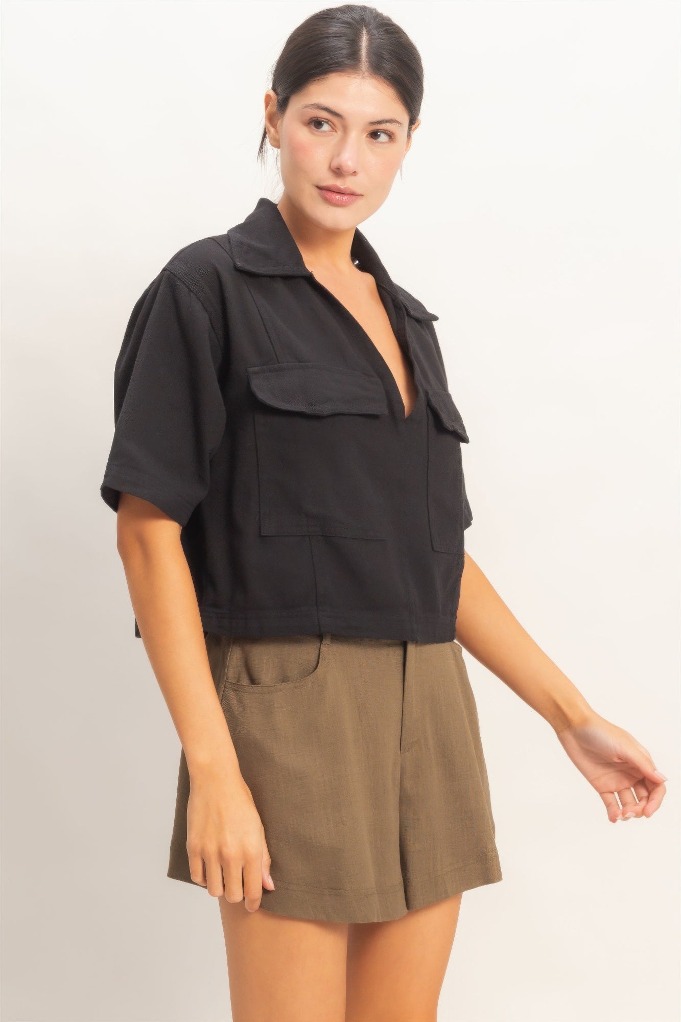 Black collared V-neck top, front view with chest pockets