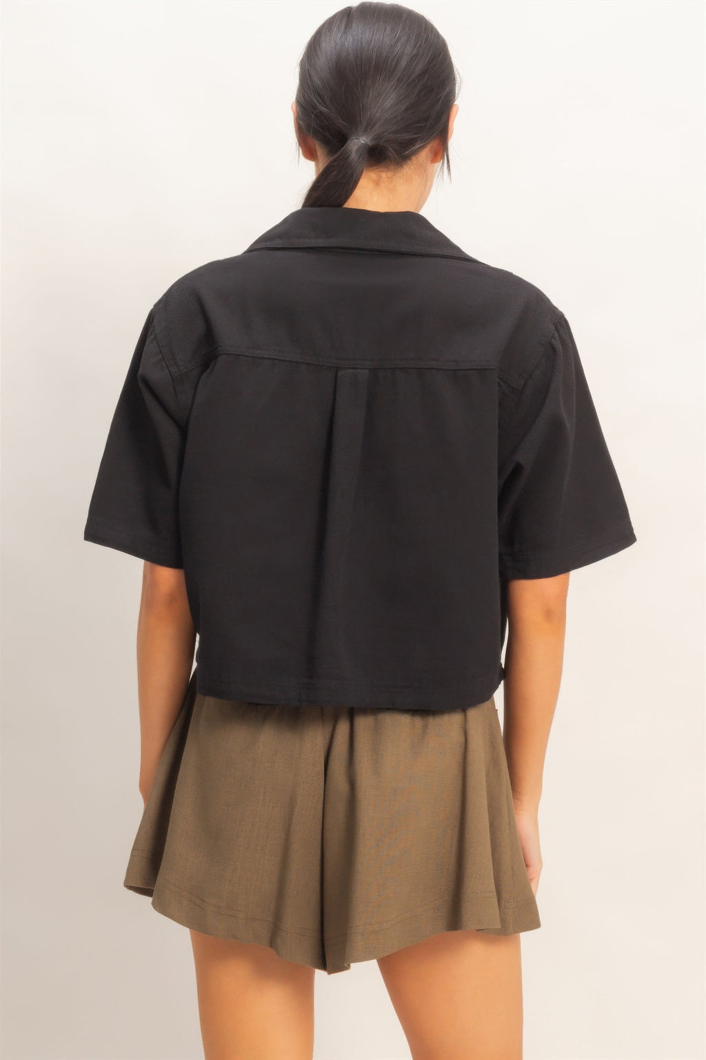 Black collared V-neck top, back view with yoke seam