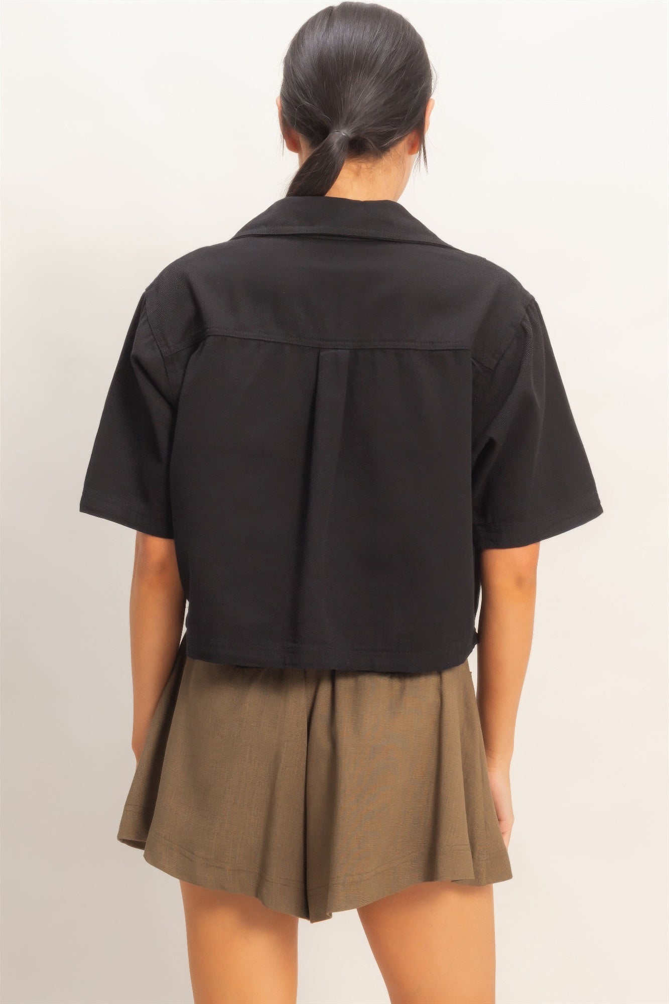 Black collared V-neck top, back view with yoke seam