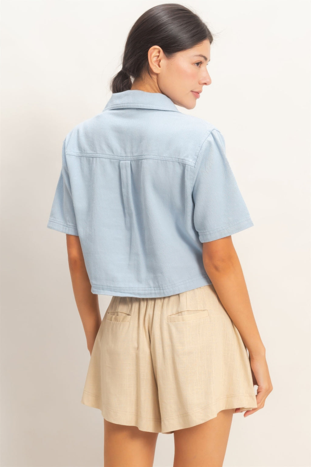 Light blue collared V-neck top, short sleeves, back view