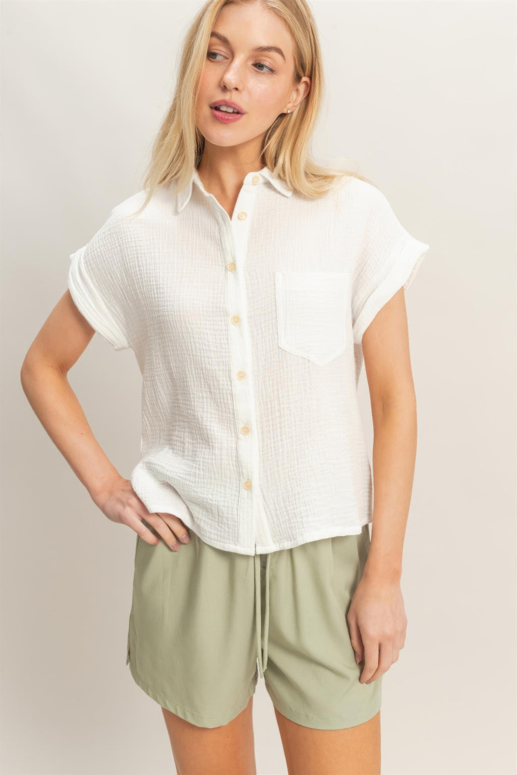Off-white rolled-sleeve button-up top with collar and front buttons