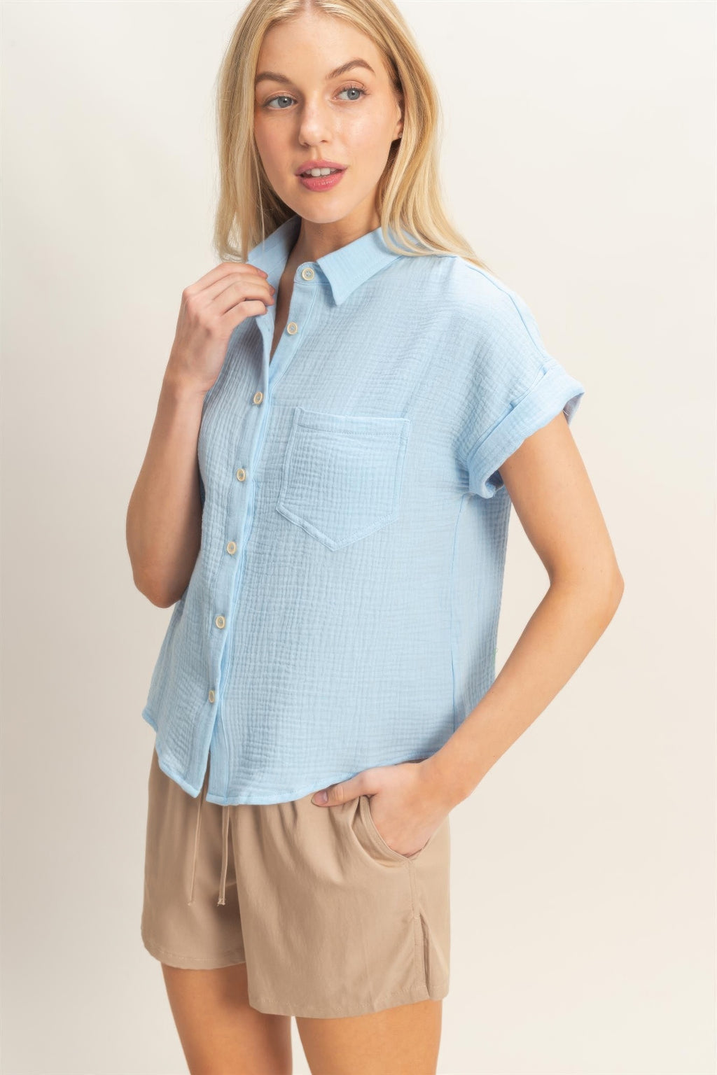 Light-blue rolled-sleeve button-up top with open collar and button front