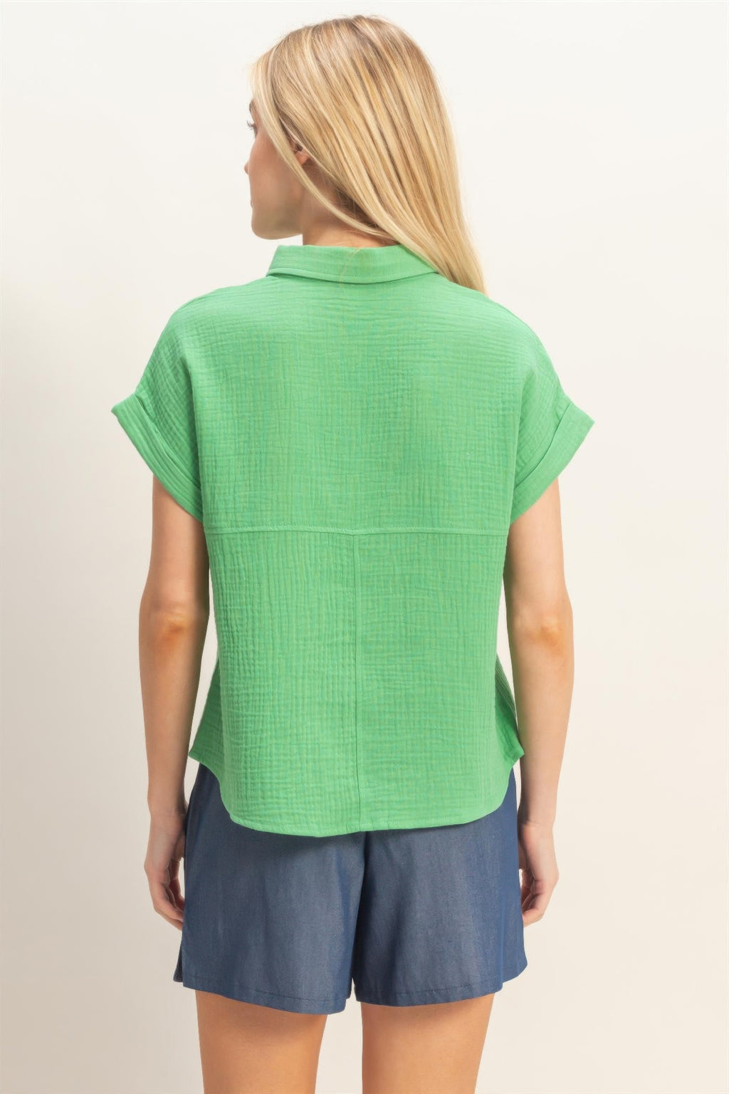 Back view of green rolled-sleeve button-up top with yoke seam
