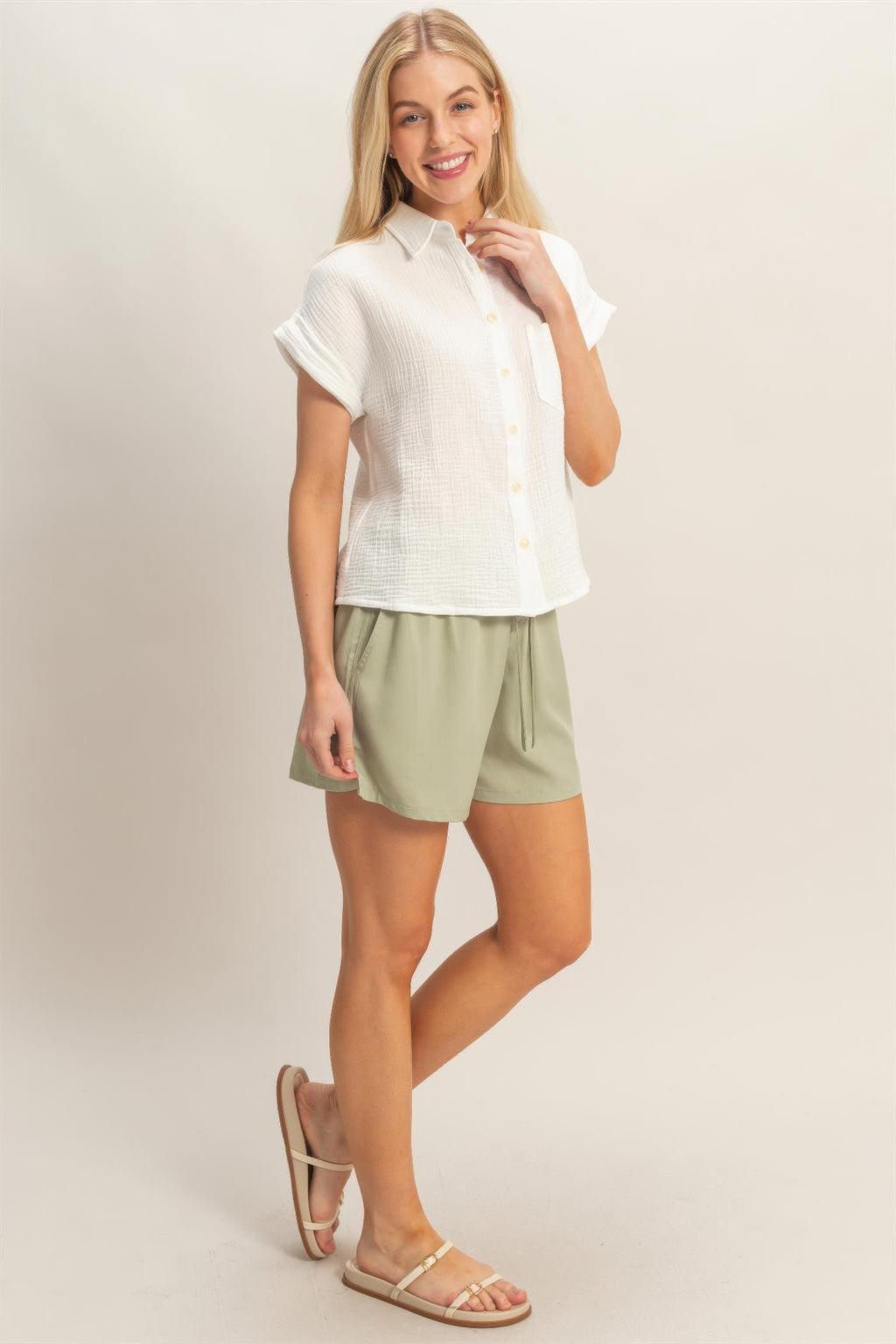 Off-white short-sleeve button-up top with chest pocket and soft drape