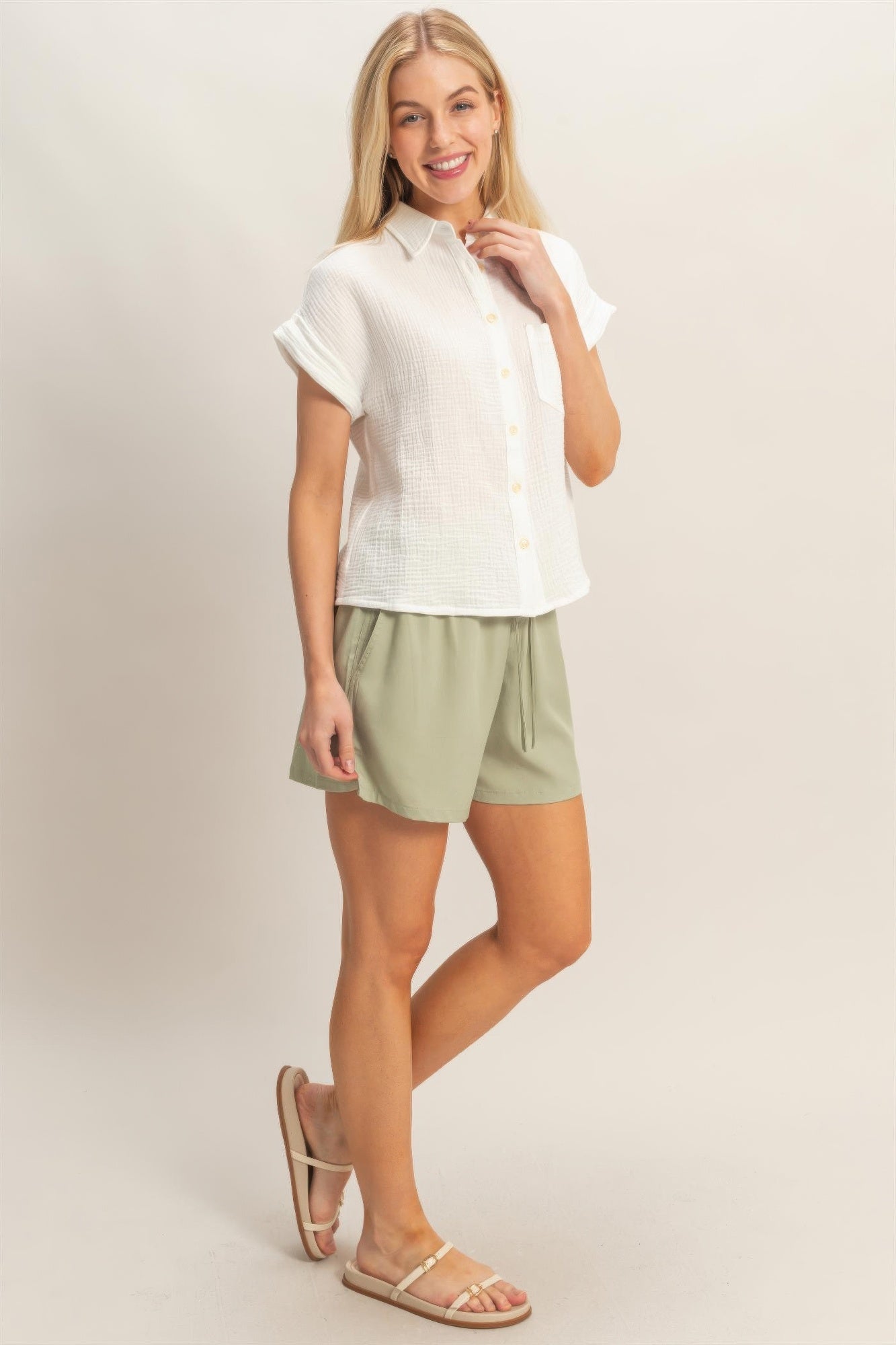 Off-white short-sleeve button-up top with chest pocket and soft drape