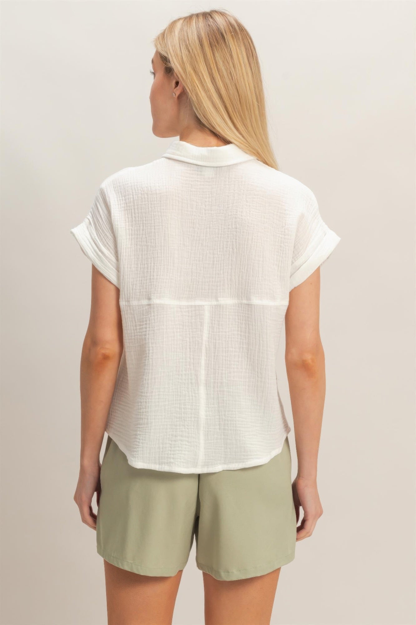 Back view of off white rolled-sleeve button-up with curved collar