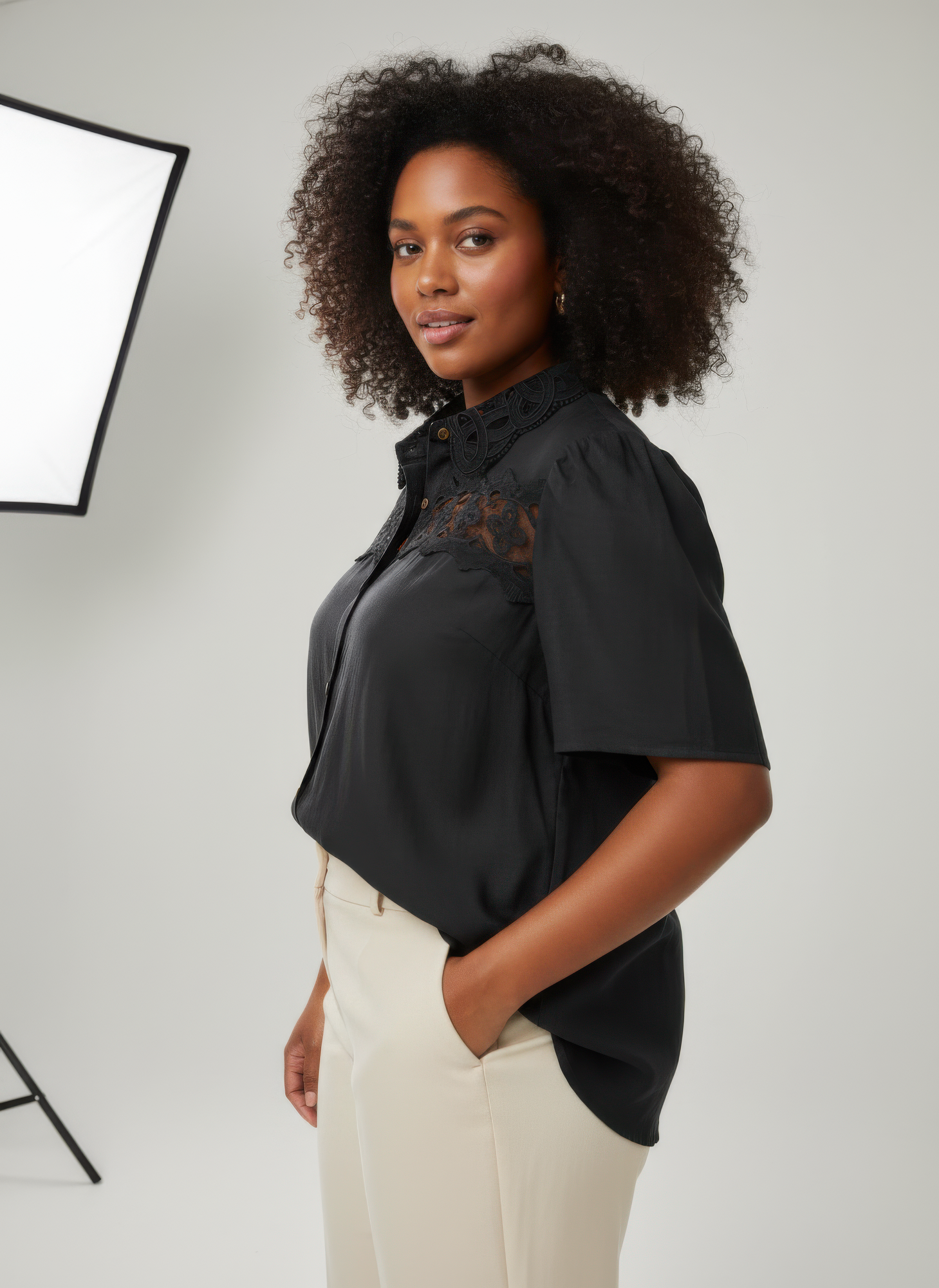 Dark lace yoke button-front collared blouse with short sleeves, side view
