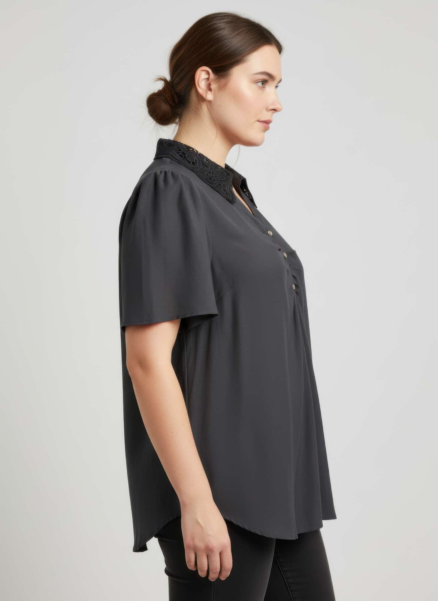 Black flutter sleeve top with lace-trimmed collar and button placket, side view