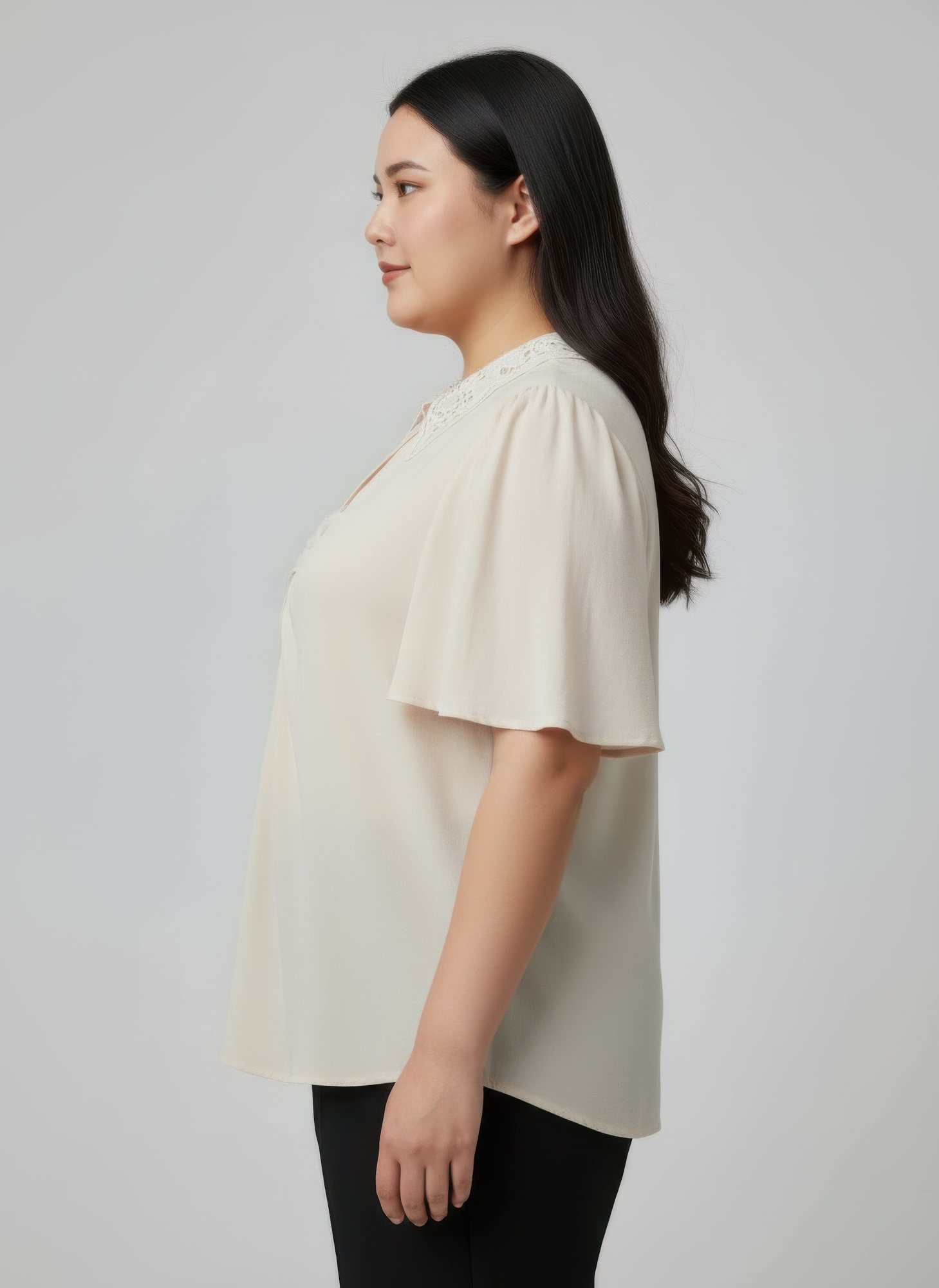 Ivory flutter sleeve top with lace-trimmed collar and button placket, side view