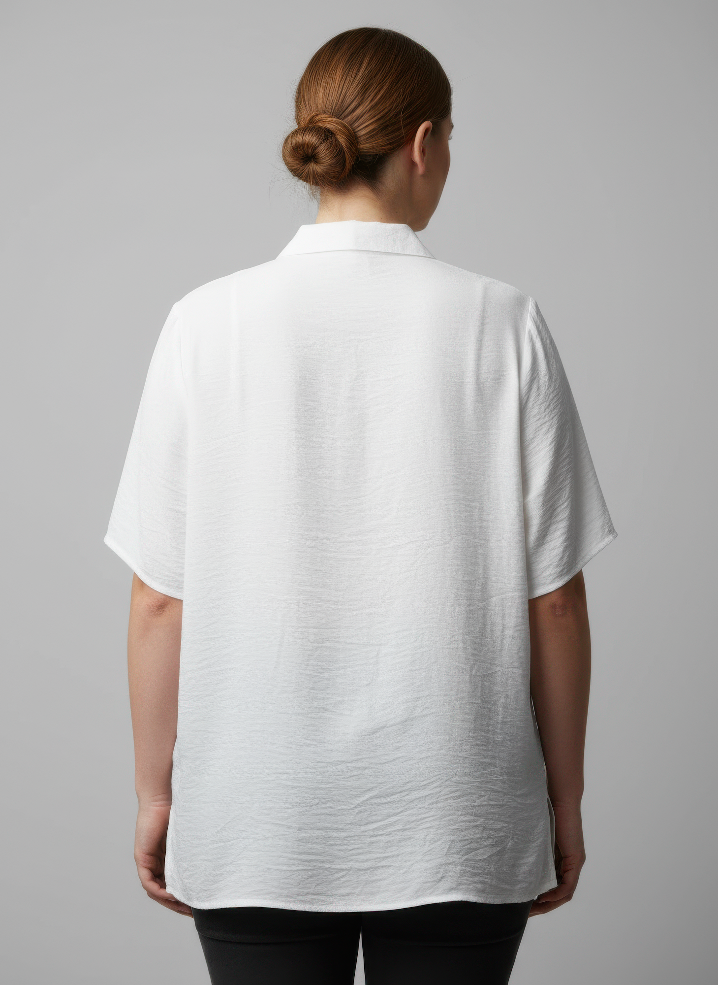 Back view of white zip-front utility knit top with stand collar