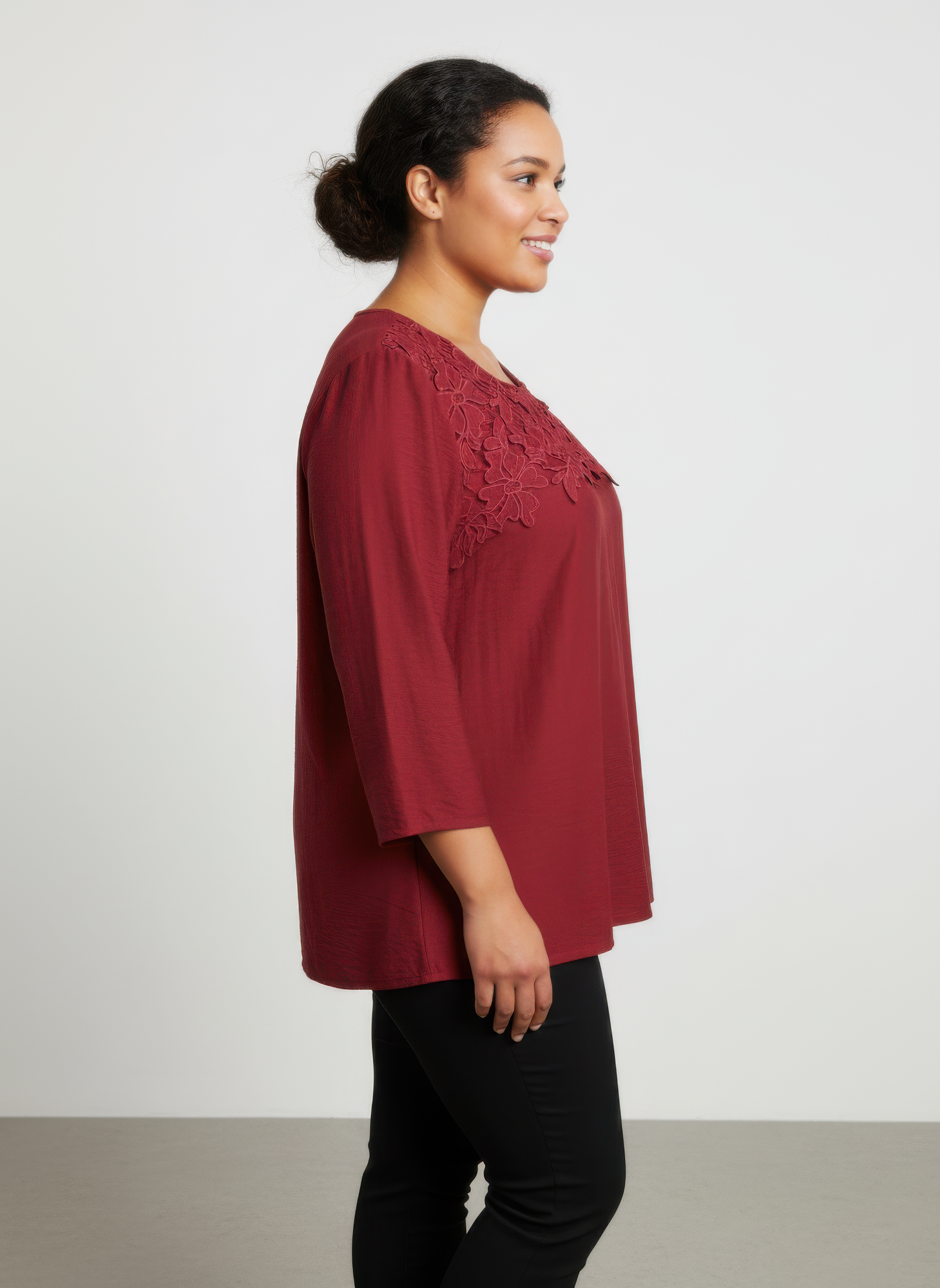 Burgundy lace yoke knit top with 3/4 sleeves, profile view