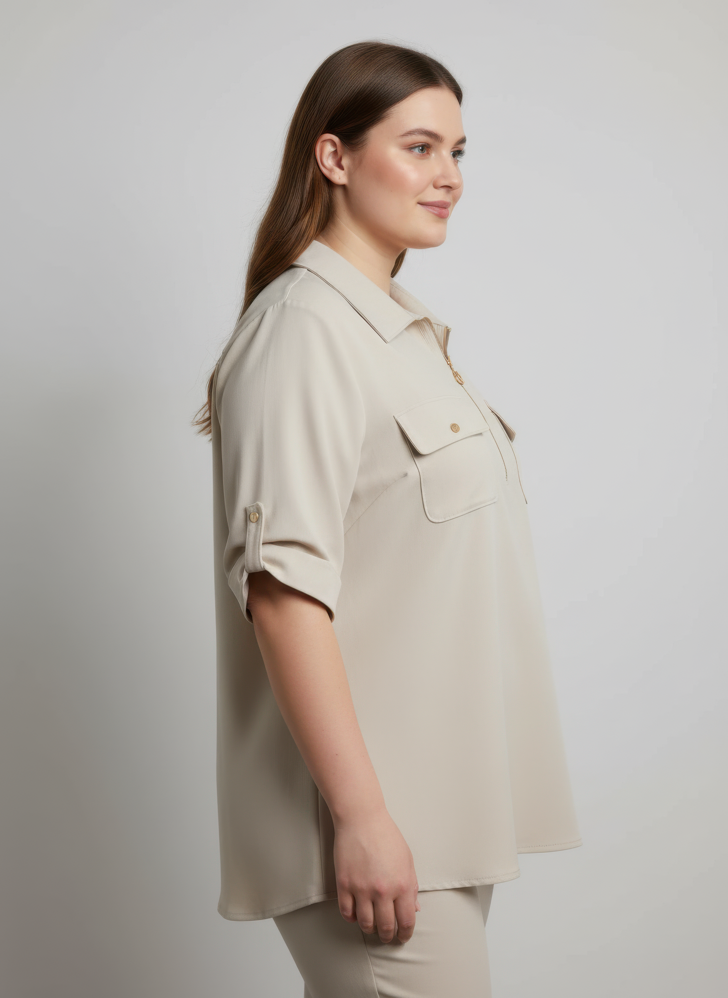 Beige zip-front tunic blouse with utility pockets, worn to the side