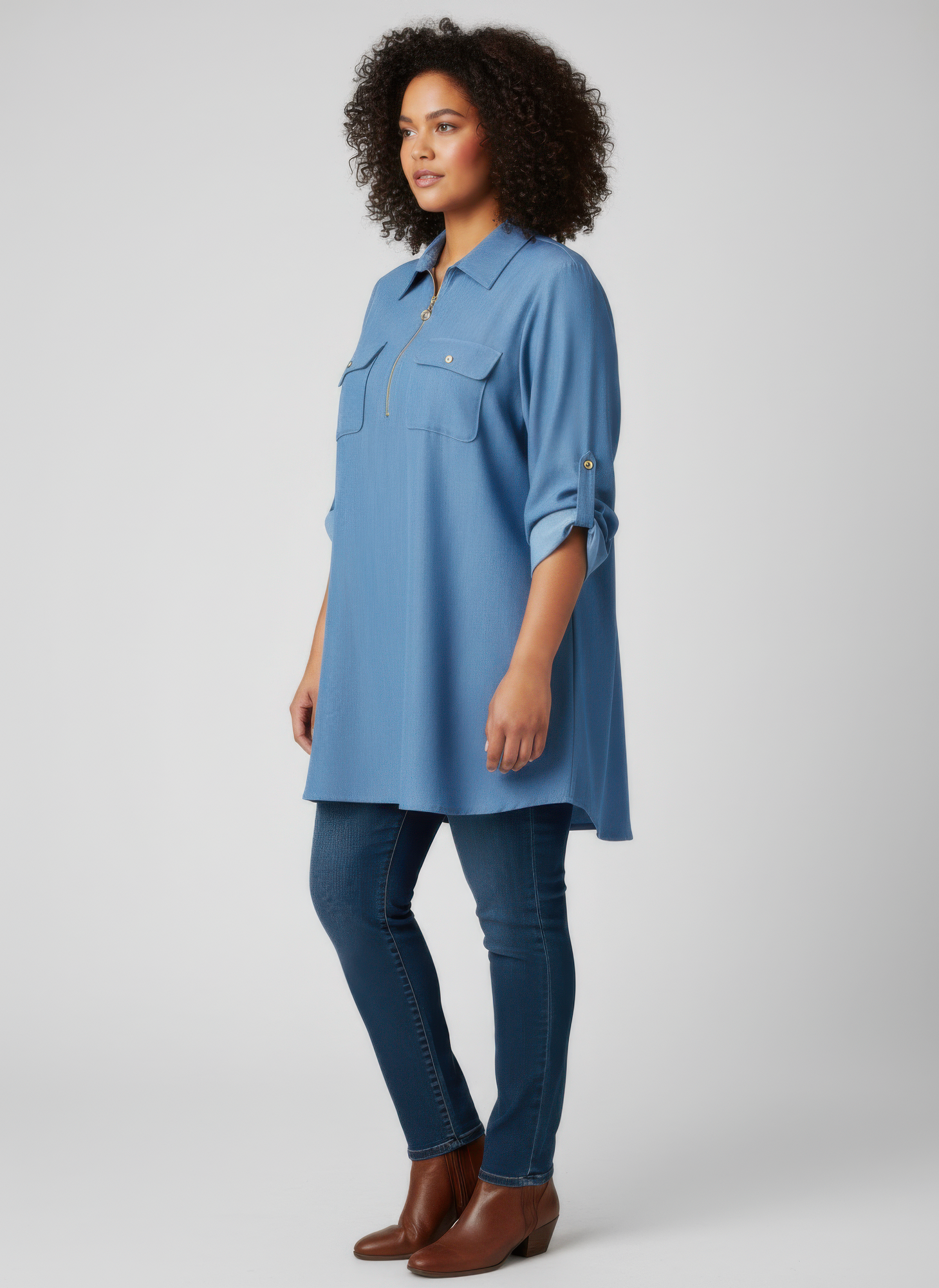 Blue zip-front tunic blouse with utility pockets and button detailing, side view