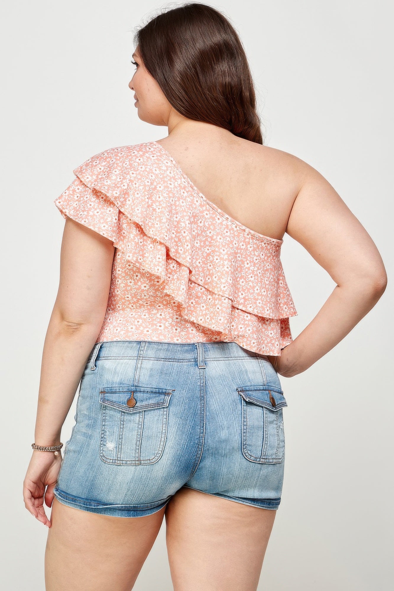 Vista posteriore bodysuit pesca a una spalla con volant e micro fiori