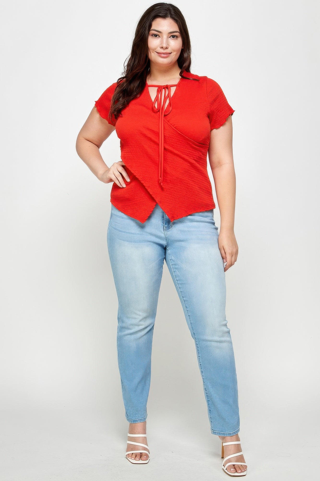 Red textured wrap top with tie-neck detail and asymmetrical drape, short sleeves