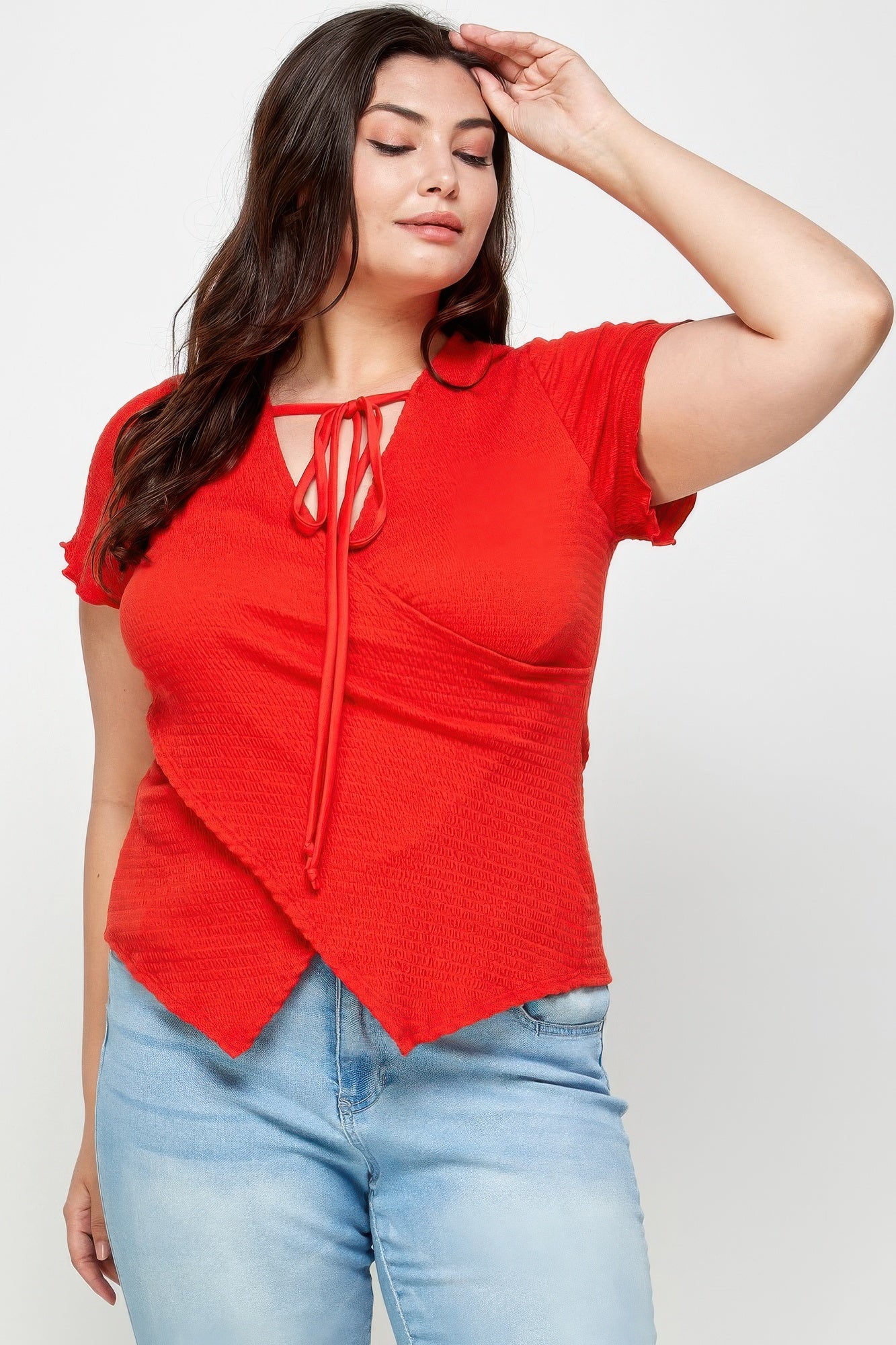 Close-up of red textured wrap top with tie-neck strings and short sleeves