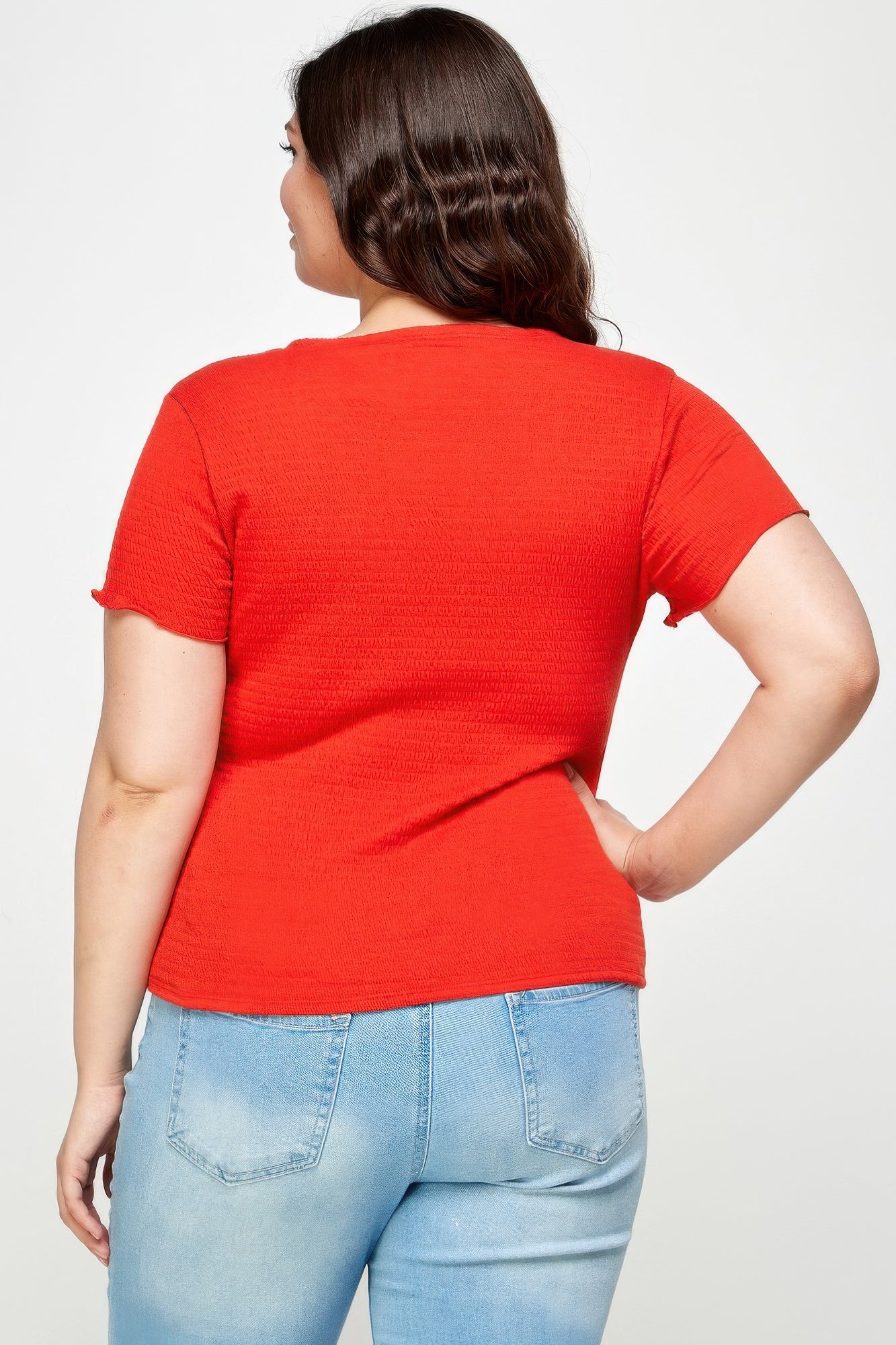 Back view of red textured wrap top with short sleeves and ruched drape